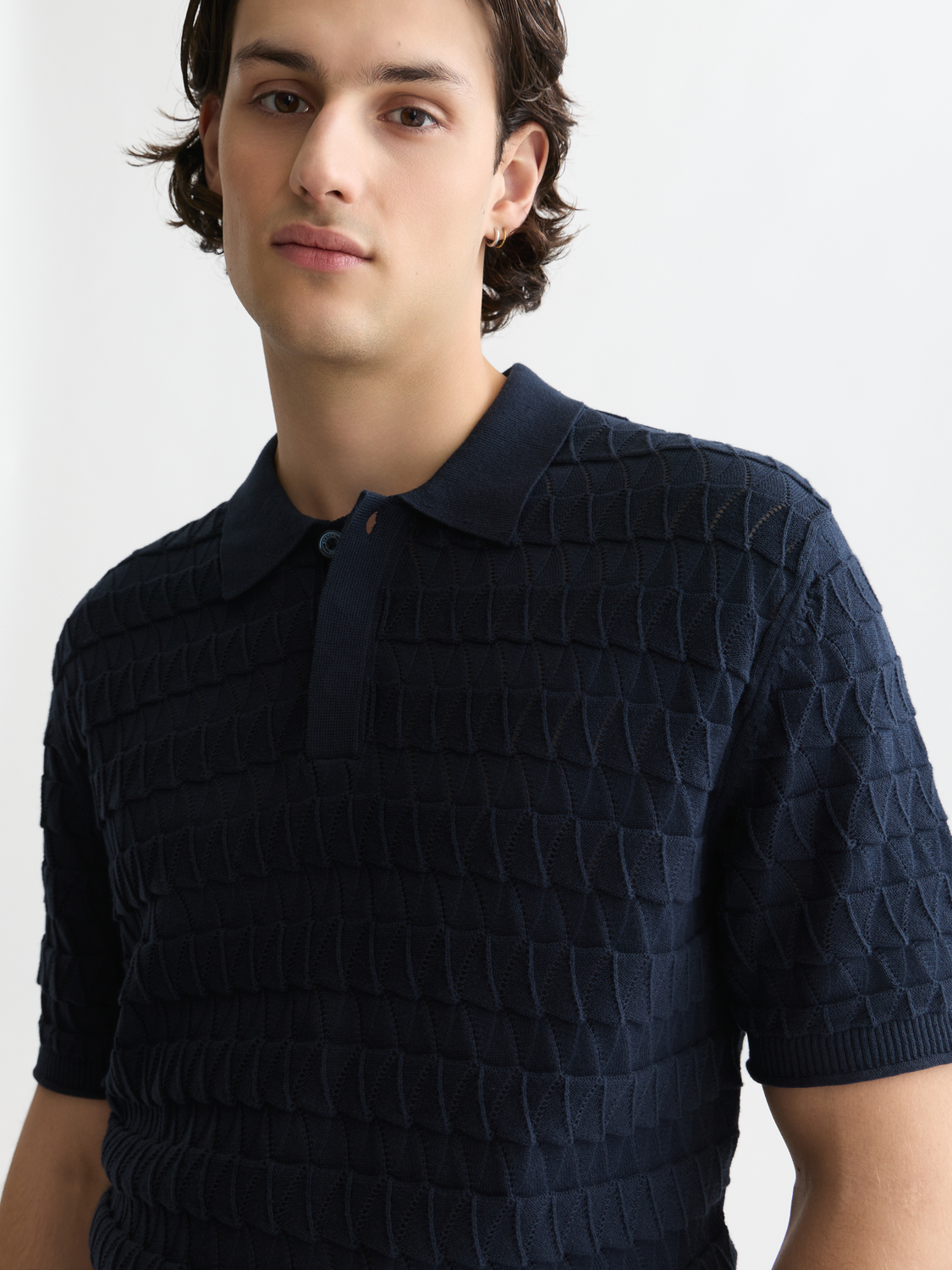 Knitted polo shirt by Scotch & Soda, featuring a classic collar and textured knit fabric, displayed on a plain background.