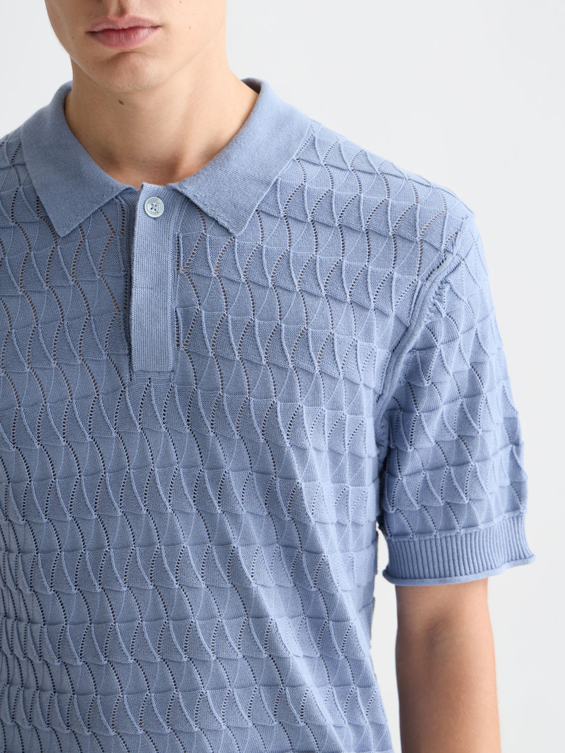 Knitted polo shirt from Scotch & Soda featuring a classic collar and textured knit fabric, displayed on a neutral background.