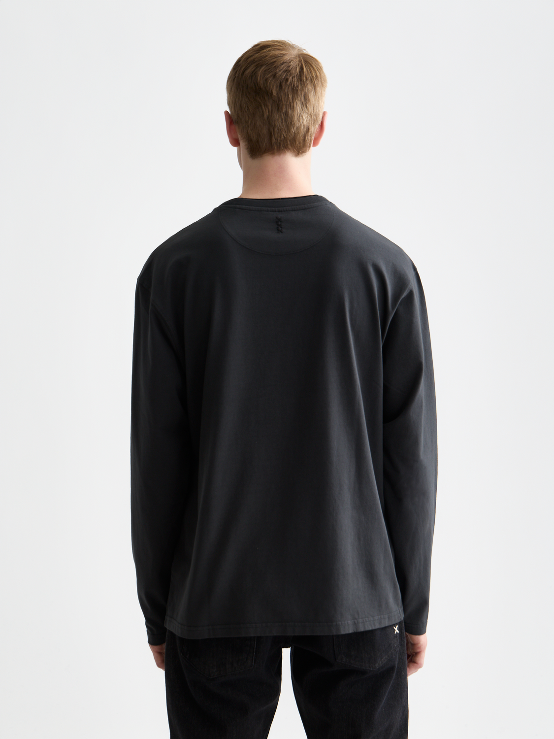 Long sleeve garment-dyed T-shirt by Scotch & Soda, shown in a close-up back view with a soft, worn-in fabric appearance.