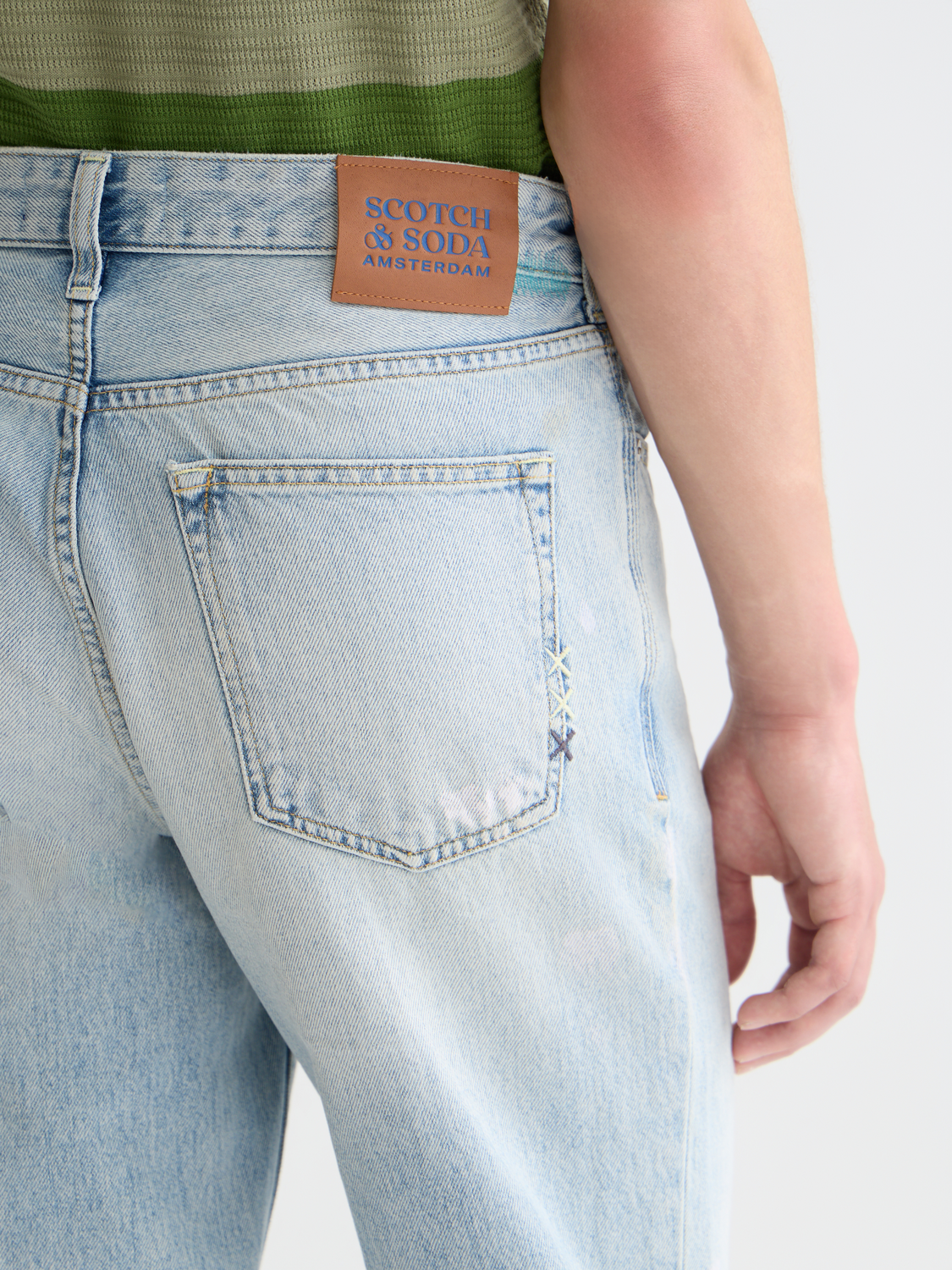 Scotch & Soda wide-fit denim jeans with classic five-pocket design and distressed detailing on a mannequin.