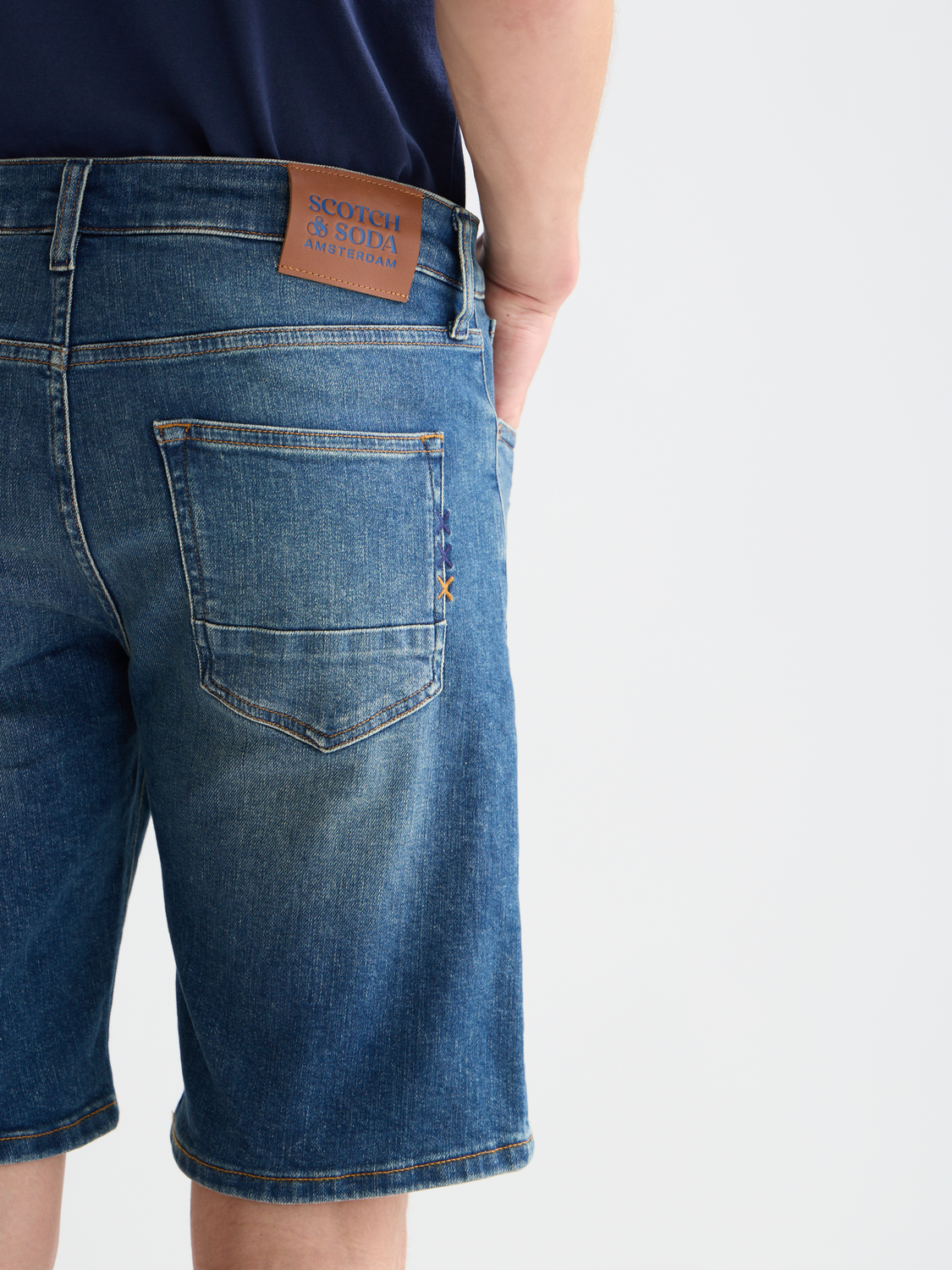 Scotch & Soda Ralston denim shorts with rolled cuffs, classic five-pocket design, and distressed detailing on light wash denim.