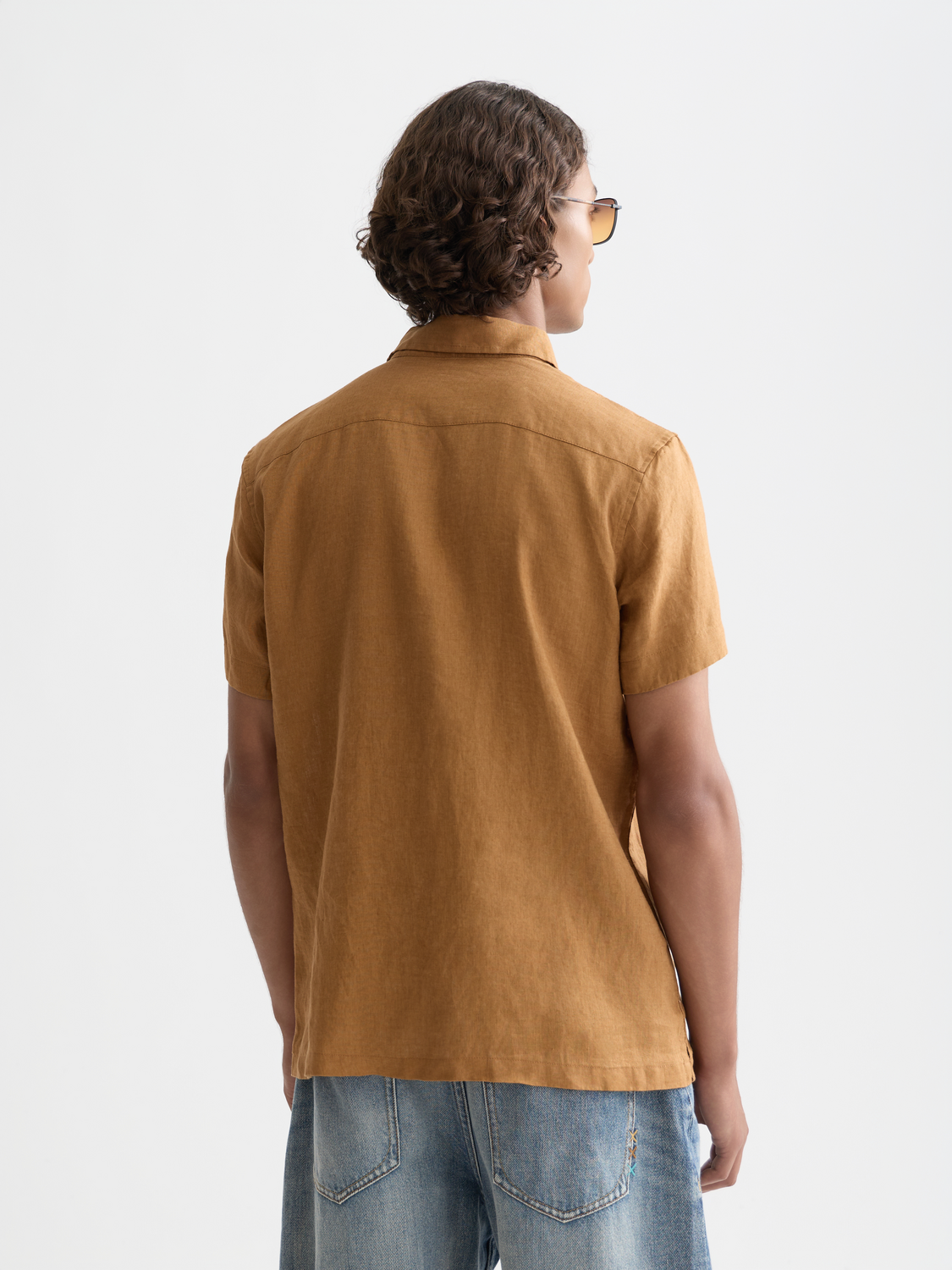 Short-sleeved linen shirt by Scotch & Soda, shown from the back with a relaxed fit and natural linen fabric.