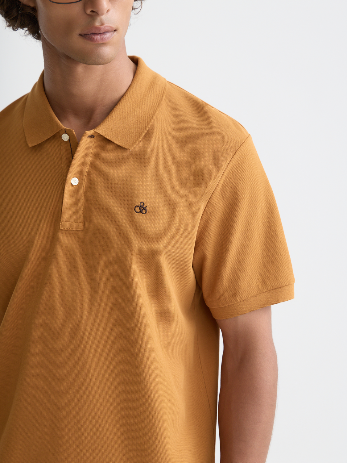 Scotch & Soda logo pique polo shirt in navy with a classic collar and short sleeves, displayed on a hanger.
