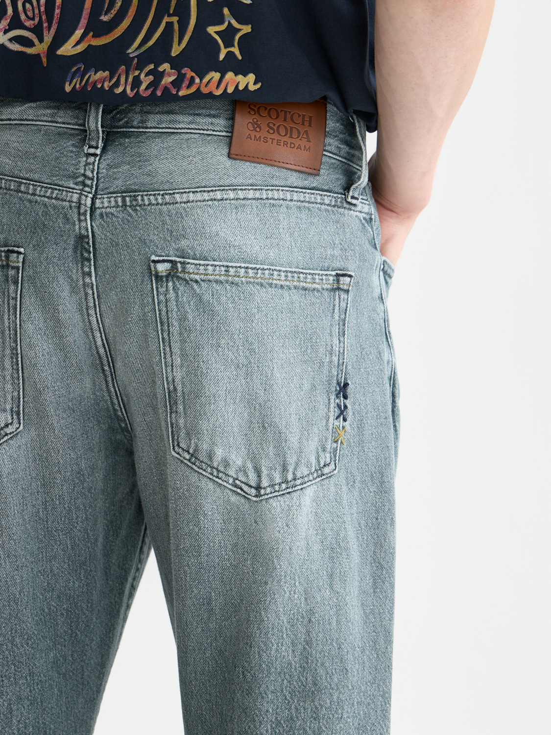 Scotch & Soda Dean tapered denim jeans showing slim fit design, front pockets, and classic blue denim fabric.