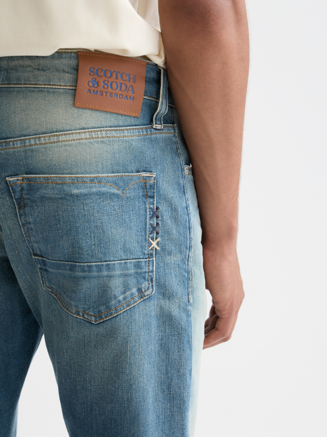 Scotch & Soda Ralston slim-fit denim jeans displayed, showing classic five-pocket design and dark wash fabric.