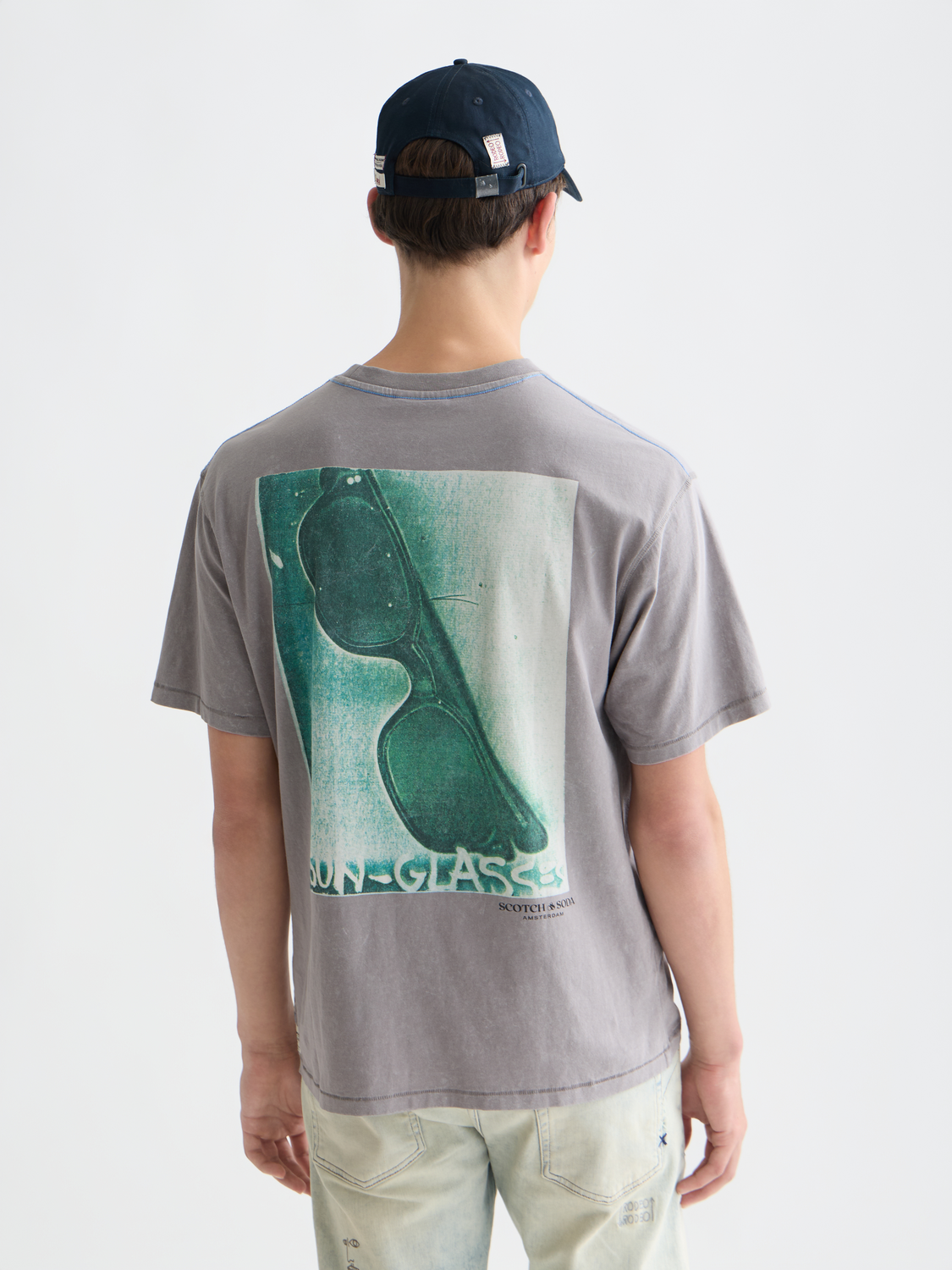 Short sleeve Scotch & Soda t-shirt featuring artwork by Basquiat with bold graphic design on black fabric.