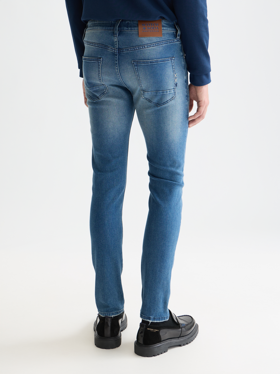 SCOTCH & SODA Ralston slim-fit denim jeans shown from the back, featuring classic blue wash and stitched pockets.