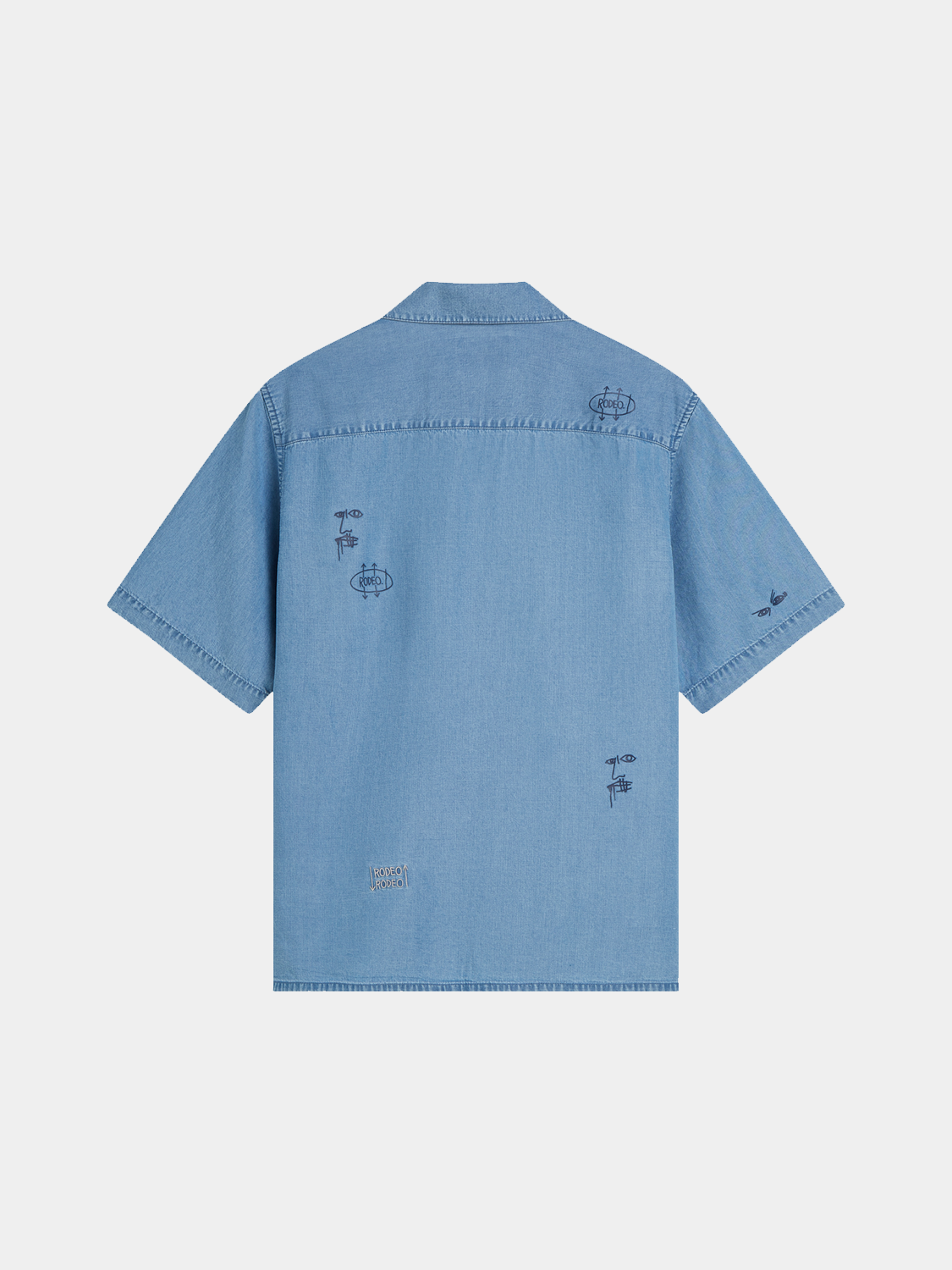 Indigo short-sleeved shirt by Scotch & Soda featuring artwork inspired by Basquiat, displayed flat on a white background.