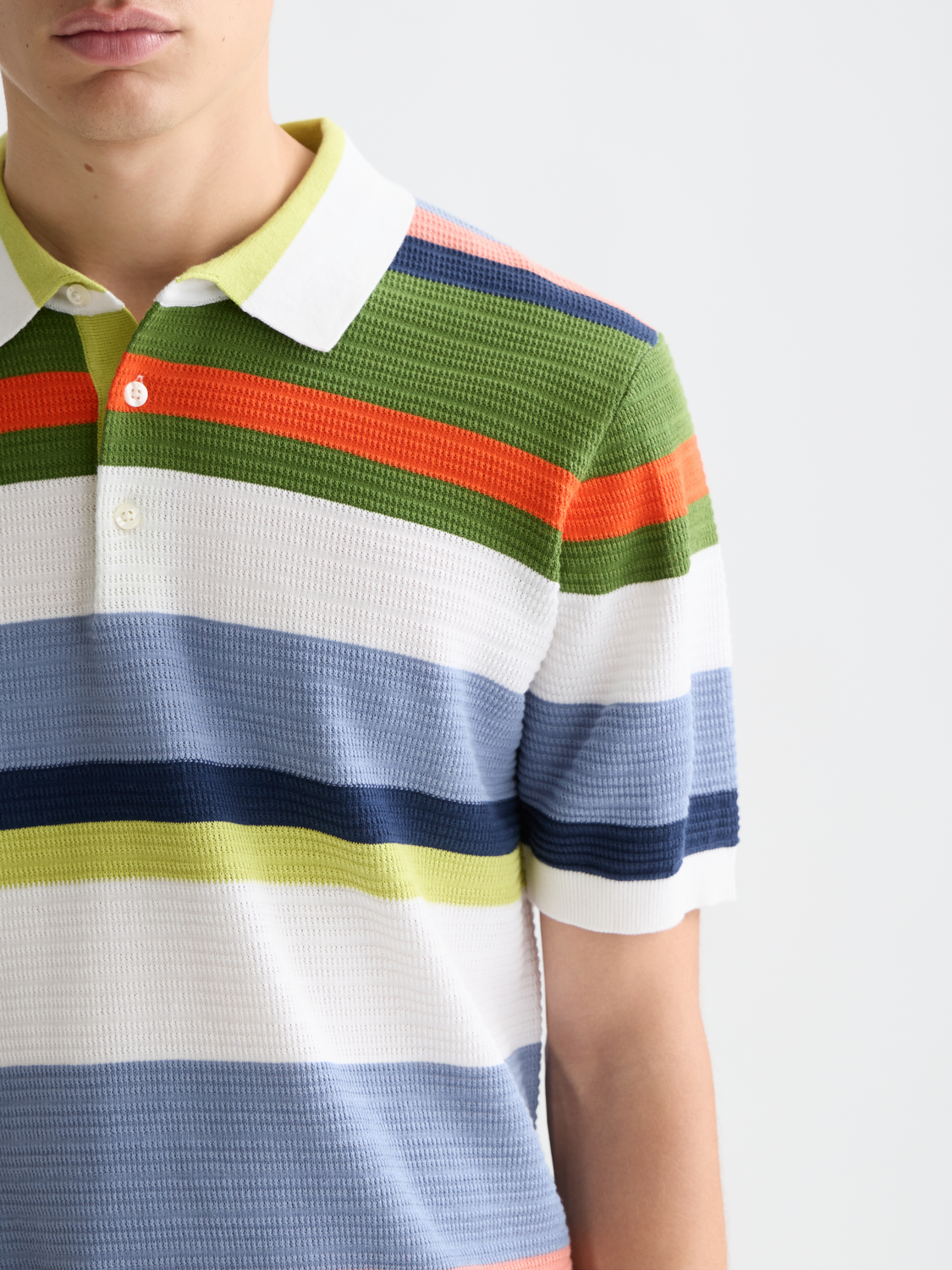 Knitted striped polo shirt by Scotch & Soda featuring a classic collar and multicolor horizontal stripes.