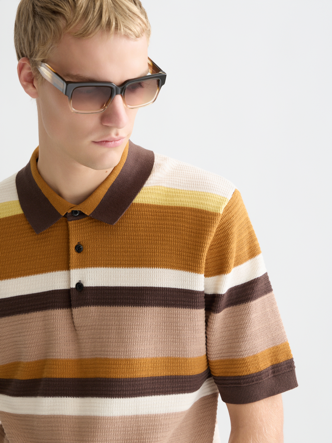 Knitted striped polo shirt by Scotch & Soda, featuring a classic collar and colorful horizontal stripes on soft fabric.