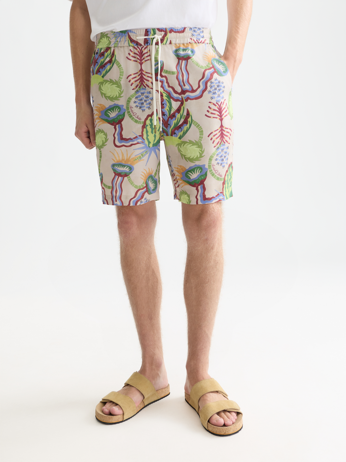 Printed shorts by Scotch & Soda featuring a vibrant floral pattern and relaxed fit, shown on a model.