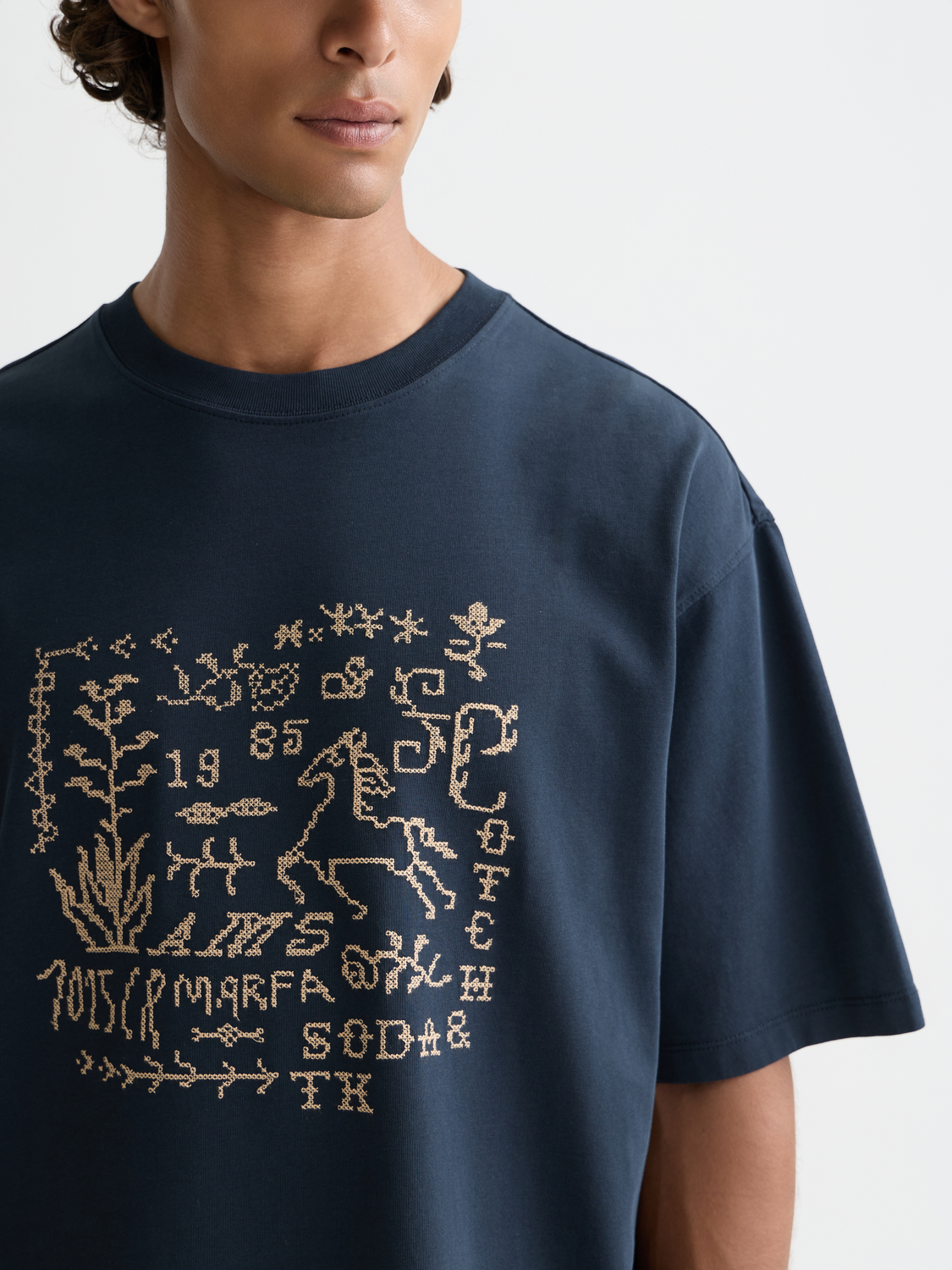 Short sleeve Scotch & Soda t-shirt featuring colorful cross-stitched artwork on the front, casual and stylish for everyday wear.
