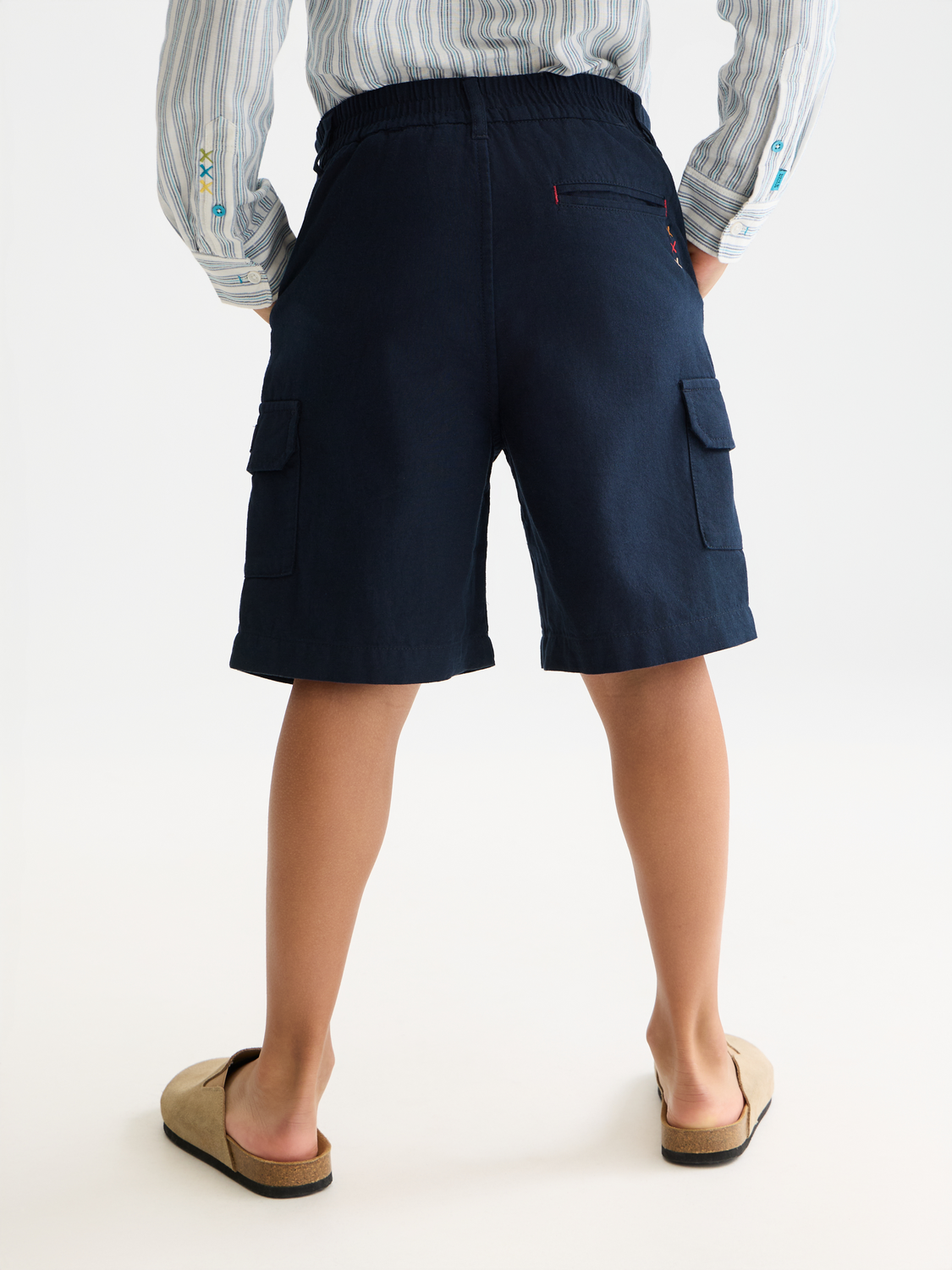 Kids' cargo shorts by Scotch & Soda, showing the back view with multiple pockets and a relaxed fit on a child model.