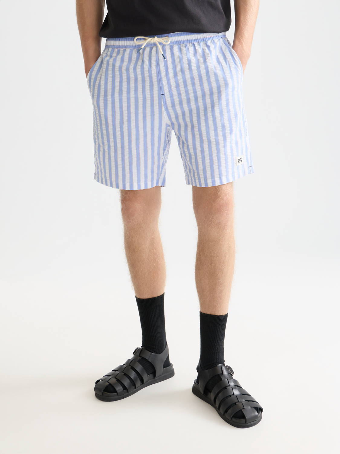 Striped mid-length swimshorts by SCOTCH & SODA, featuring colorful horizontal stripes and a comfortable fit for swimming or beachwear.