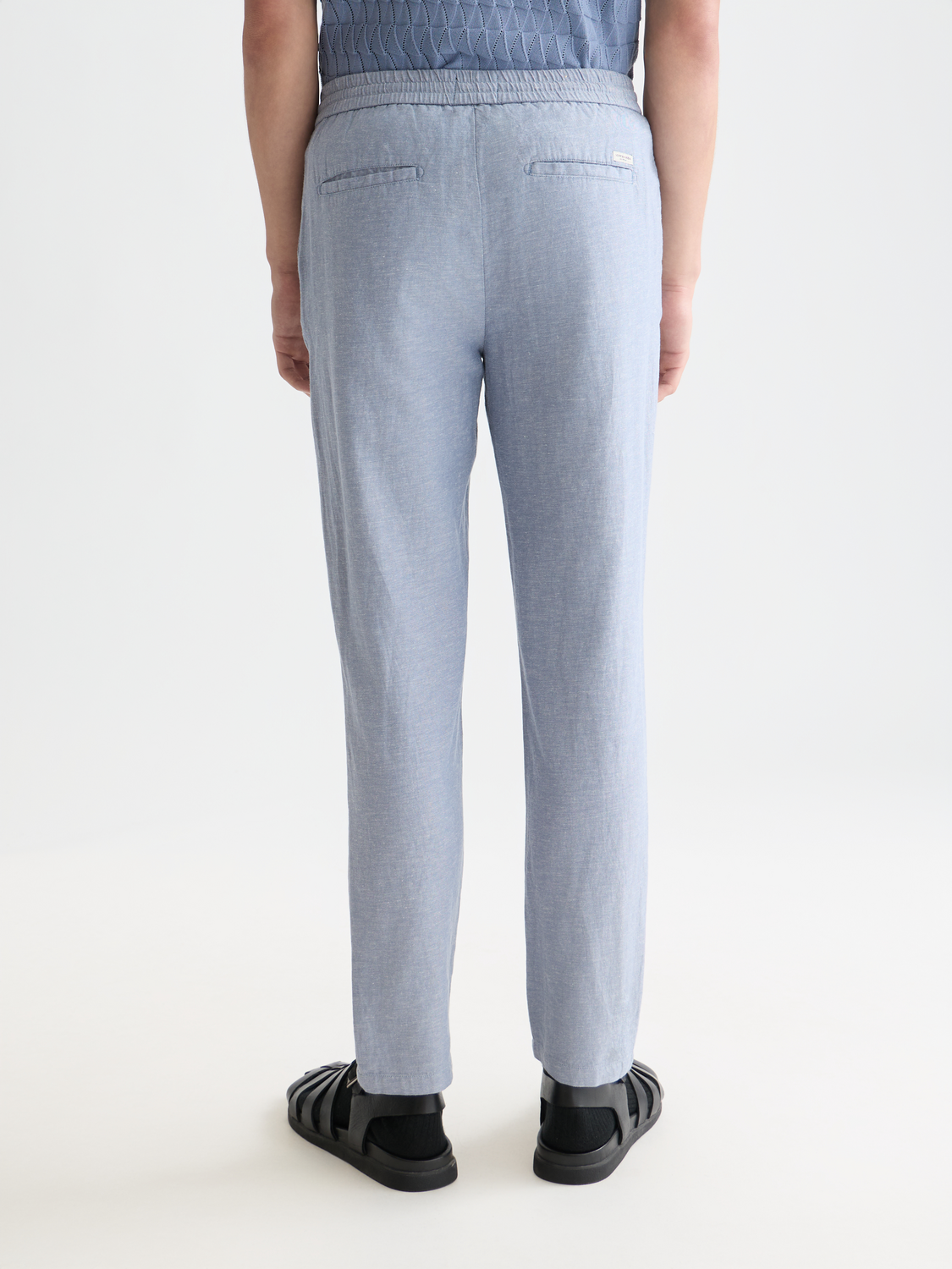 SCOTCH & SODA Warren joggers, stylish casual pants in a dark color, shown from the back with a relaxed fit and elastic waistband.