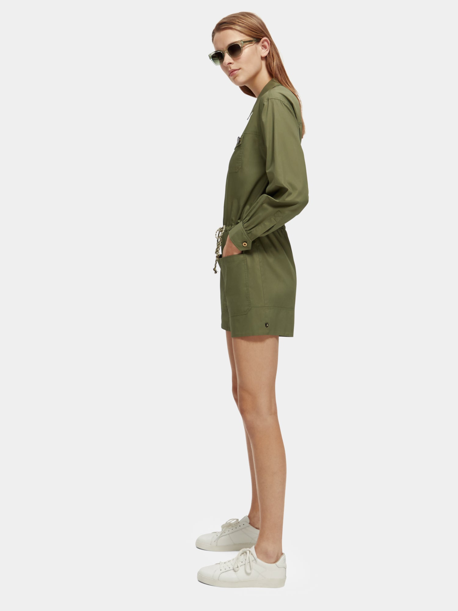 SCOTCH & SODA military playsuit jumpsuit featuring a structured design, front pockets, and adjustable straps, worn by a model.