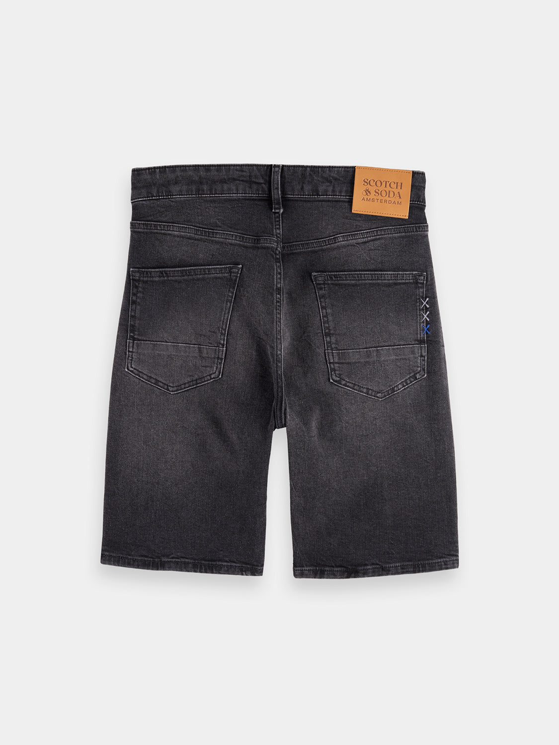 Back view of Ralston denim shorts by SCOTCH & SODA showing distressed details and frayed hem on casual denim shorts.