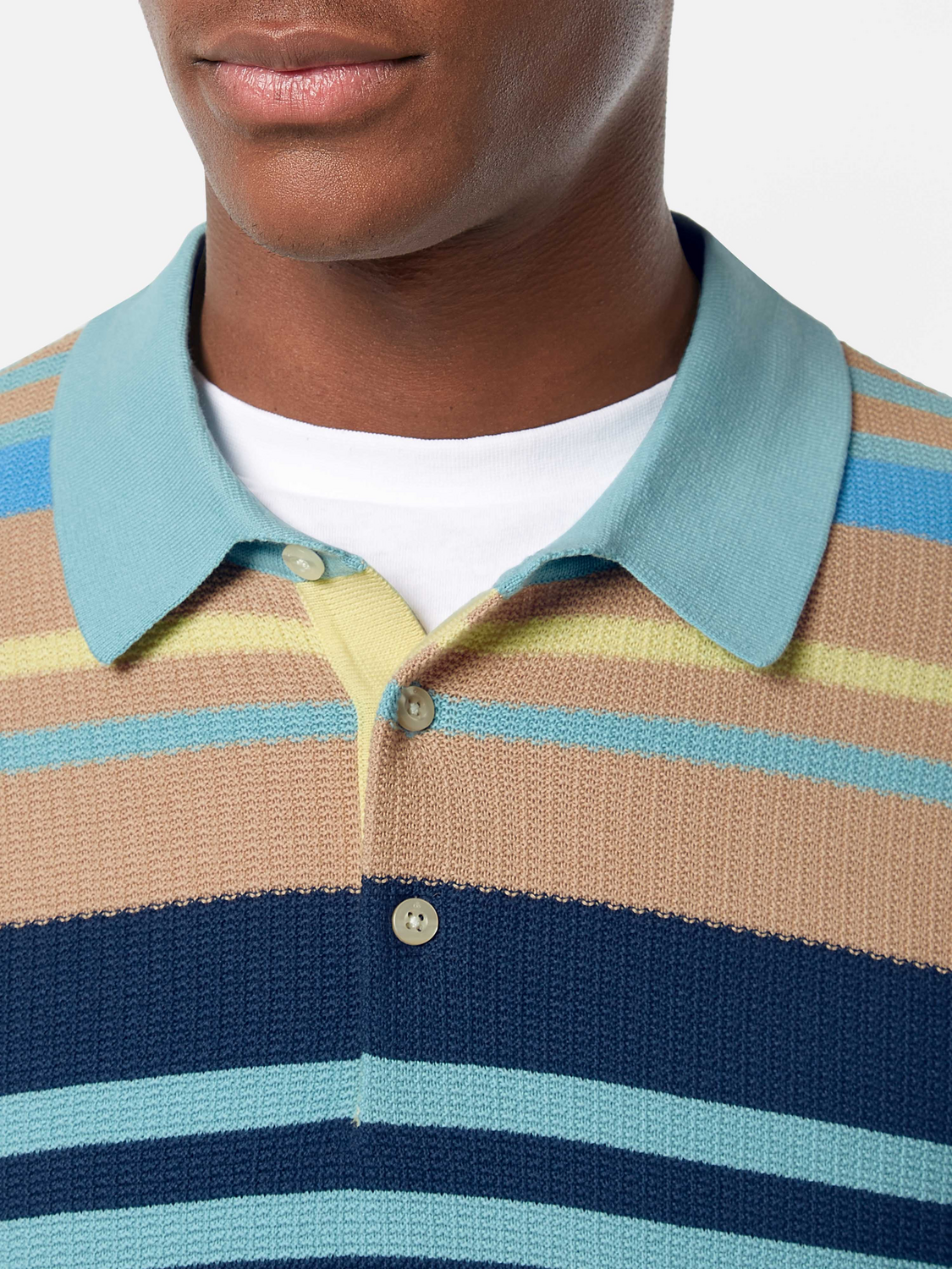 Knitted polo shirt by Scotch & Soda, featuring a classic collar and textured knit fabric, shown in a neutral color.