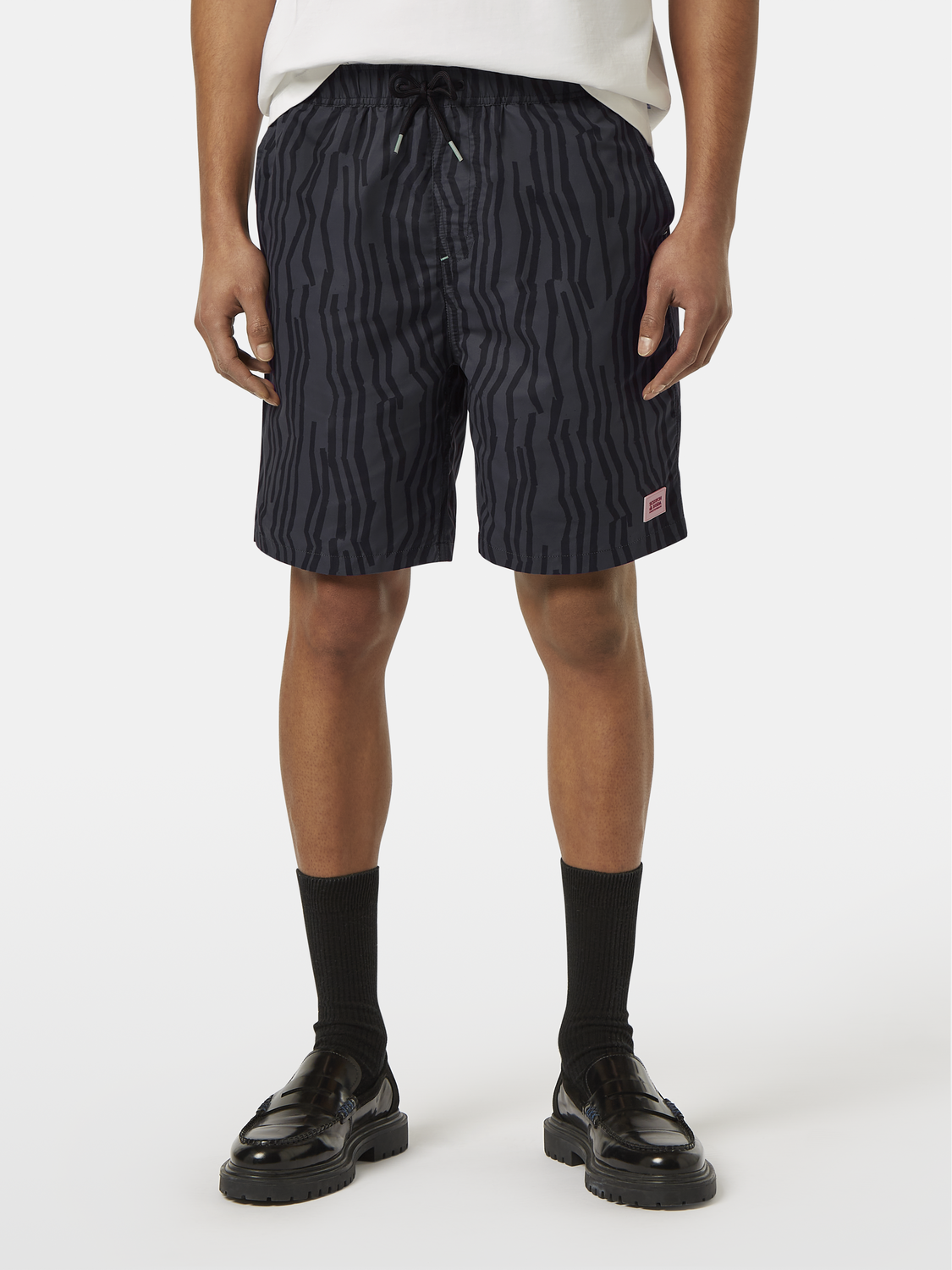 Printed swimshorts from Scotch & Soda featuring vibrant patterns, designed for men's swimwear, displayed laid flat.
