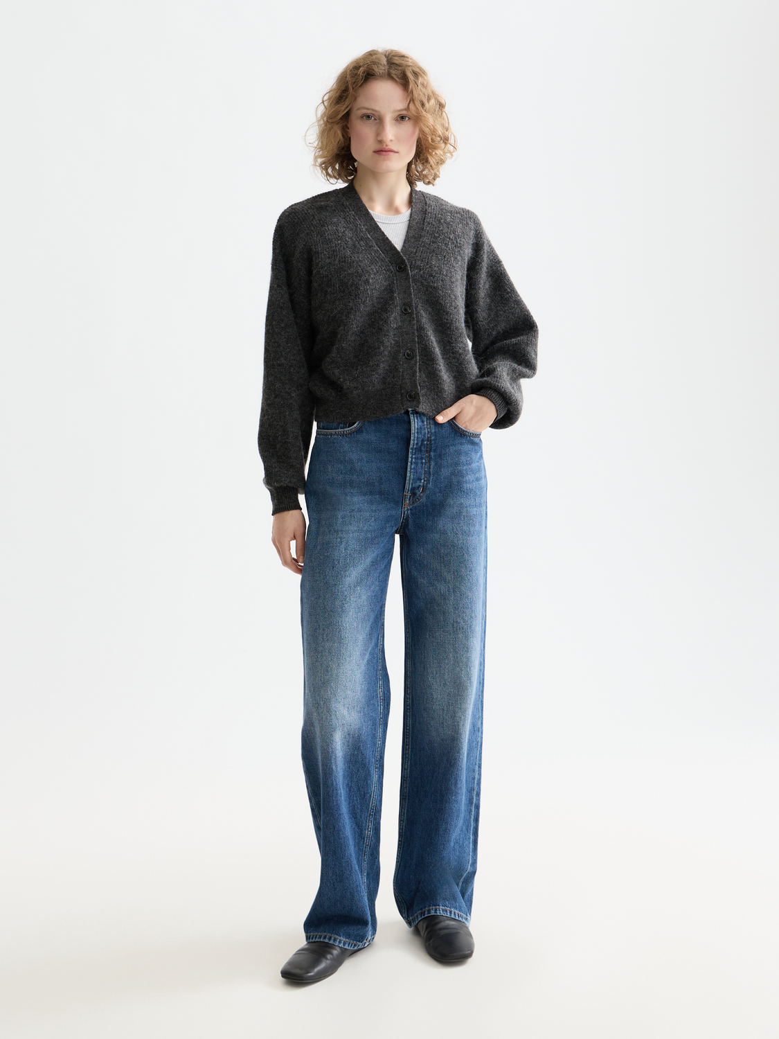 Fuzzy knit cardigan by Scotch & Soda, featuring soft texture and button closure, worn by a model in a fashion photoshoot.