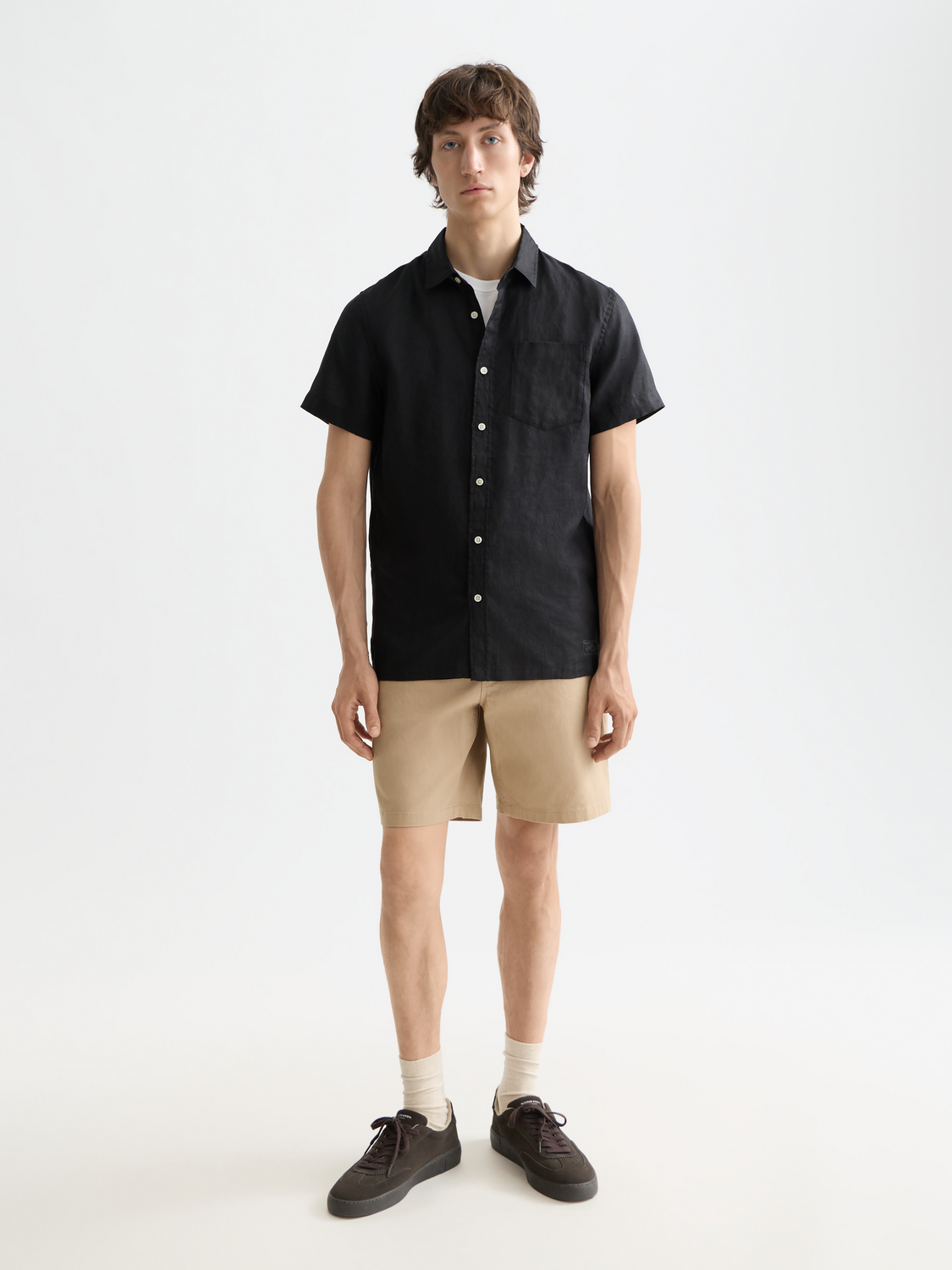 Light beige short-sleeved linen shirt from Scotch & Soda, displayed on a hanger with a relaxed fit and breathable fabric.