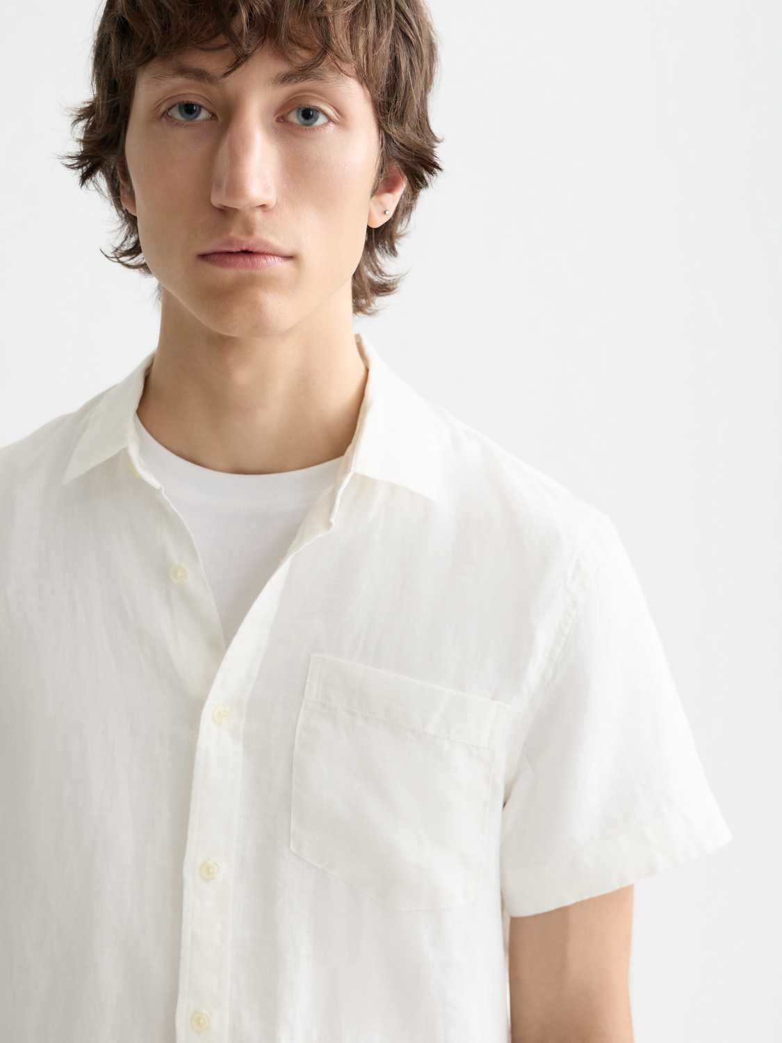 Light beige short-sleeved linen shirt by Scotch & Soda, featuring a relaxed fit and classic collar, displayed on a hanger.