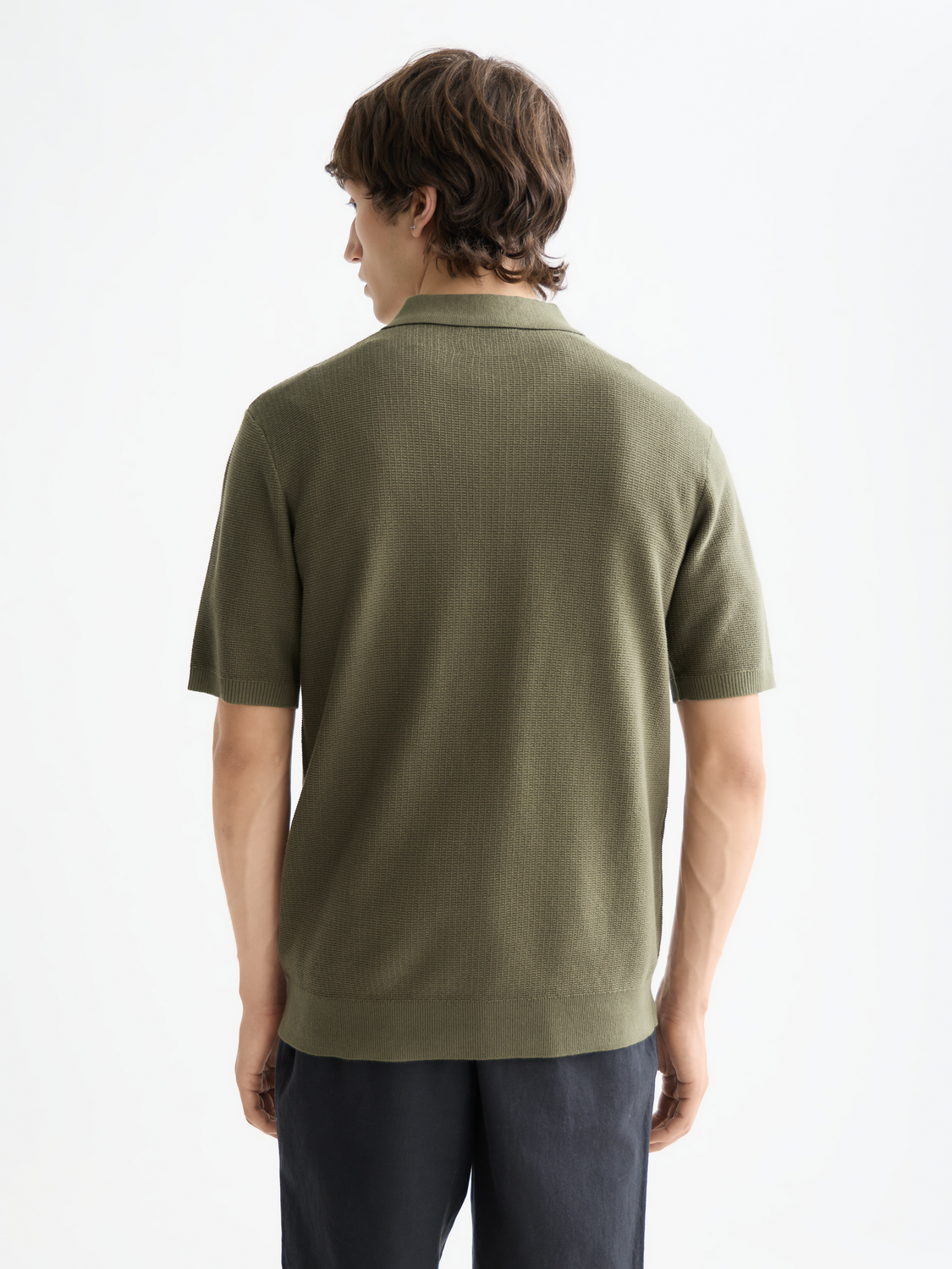 Black knitted polo shirt by Scotch & Soda featuring a classic collar and textured knit fabric.