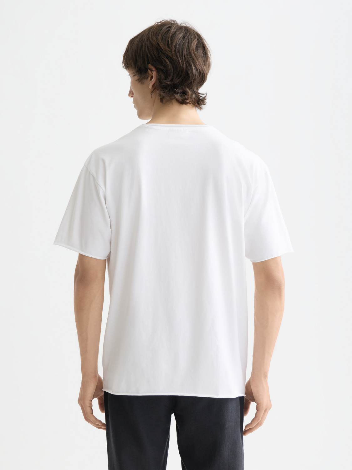 Raw-edged Scotch & Soda short sleeve t-shirt with distressed hem, black color, casual style, visible fabric texture and stitching details.