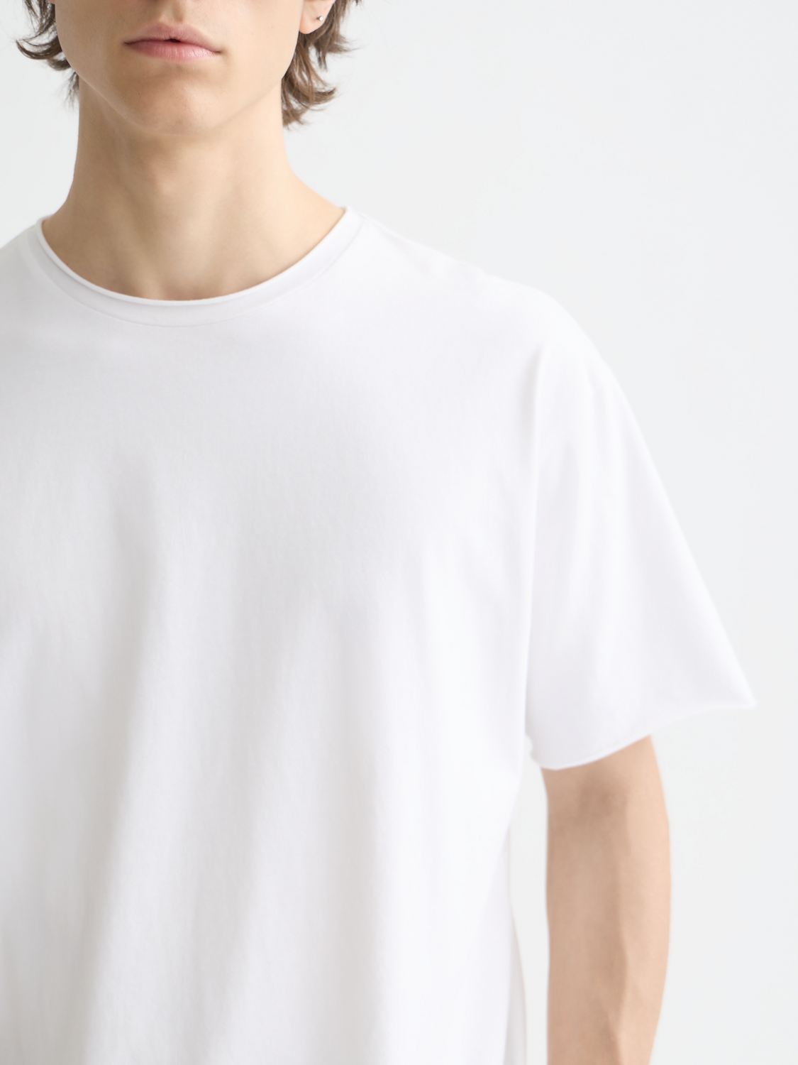 Raw-edged Scotch & Soda short sleeve t-shirt displayed on a hanger, showcasing its casual fit and distressed neckline.