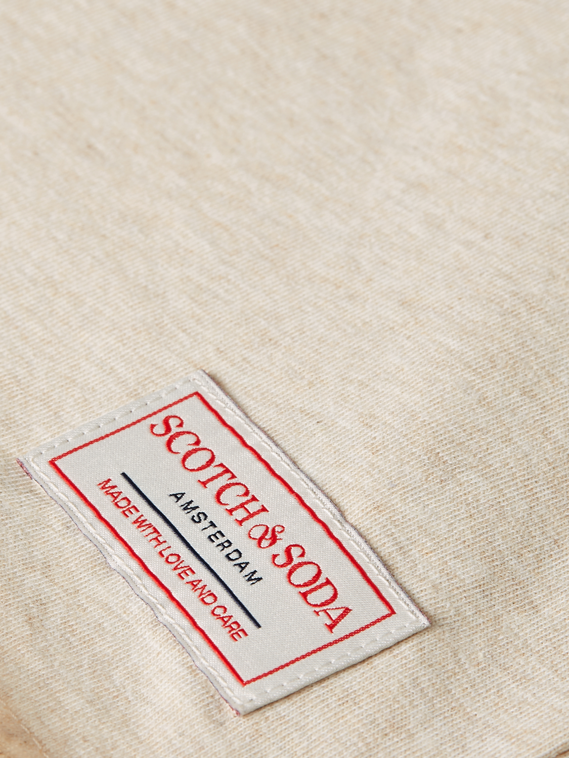 Raw-edged S/S T-shirt by Scotch & Soda featuring a casual fit and distressed hem, displayed on a neutral background.