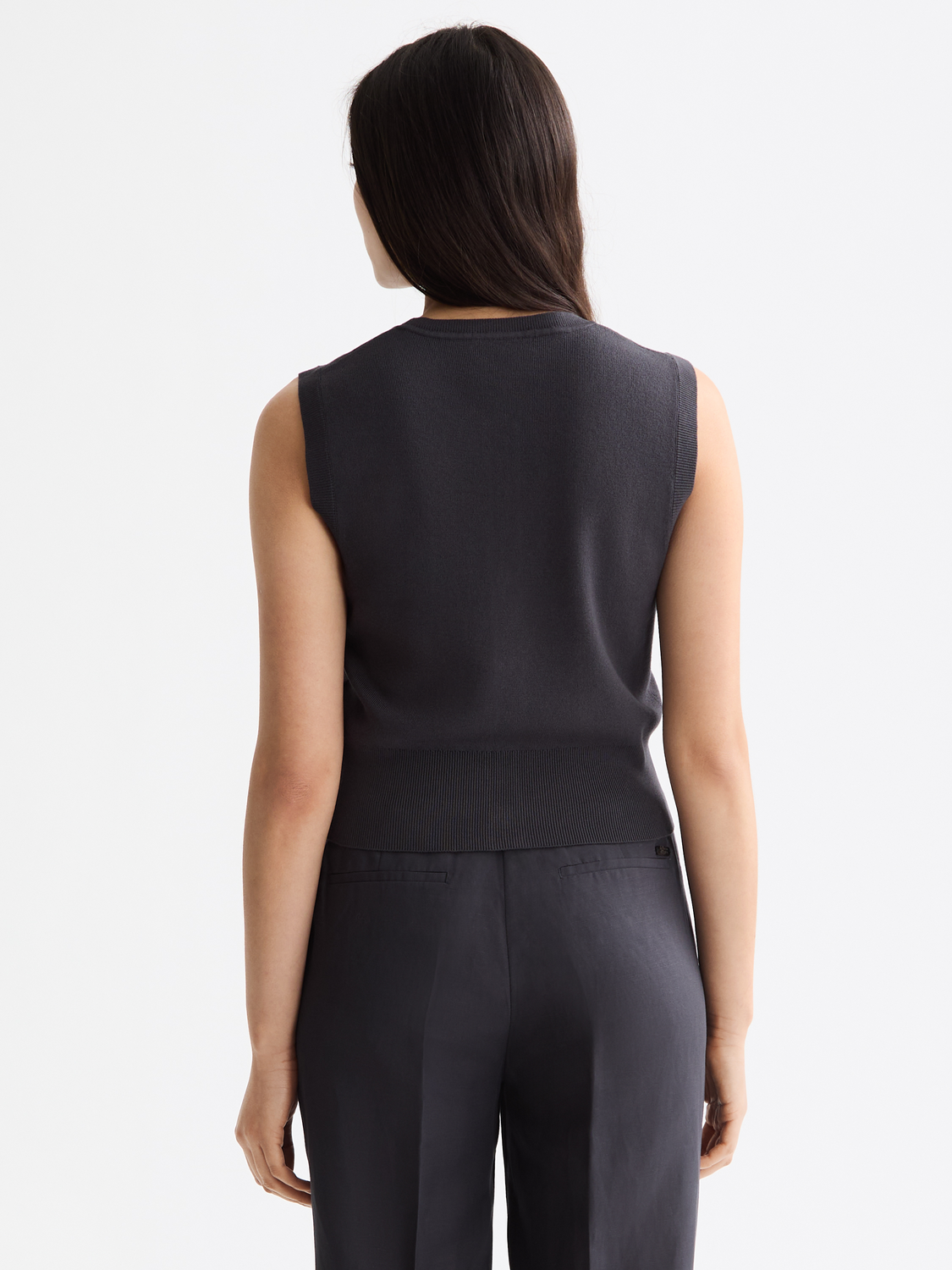 Cream knitted spencer top by Scotch & Soda, showing the back view with ribbed detailing and a fitted silhouette.