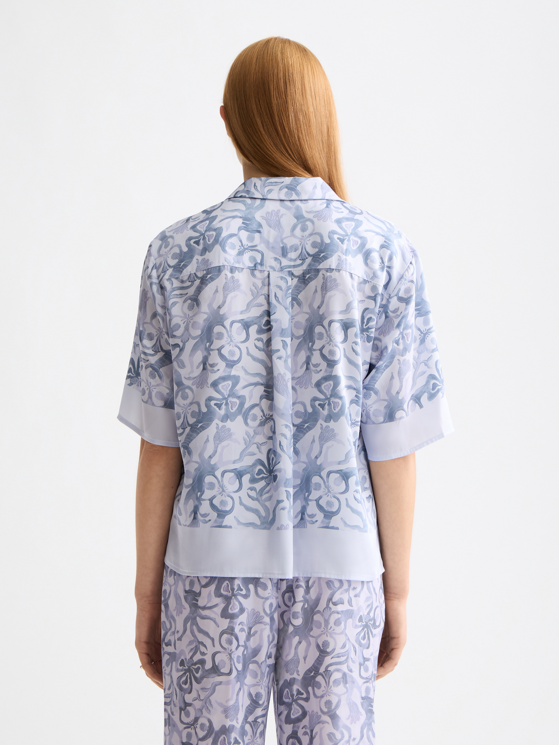 Printed short-sleeved shirt by Scotch & Soda featuring a vibrant design and casual fit, displayed on a wooden mannequin.