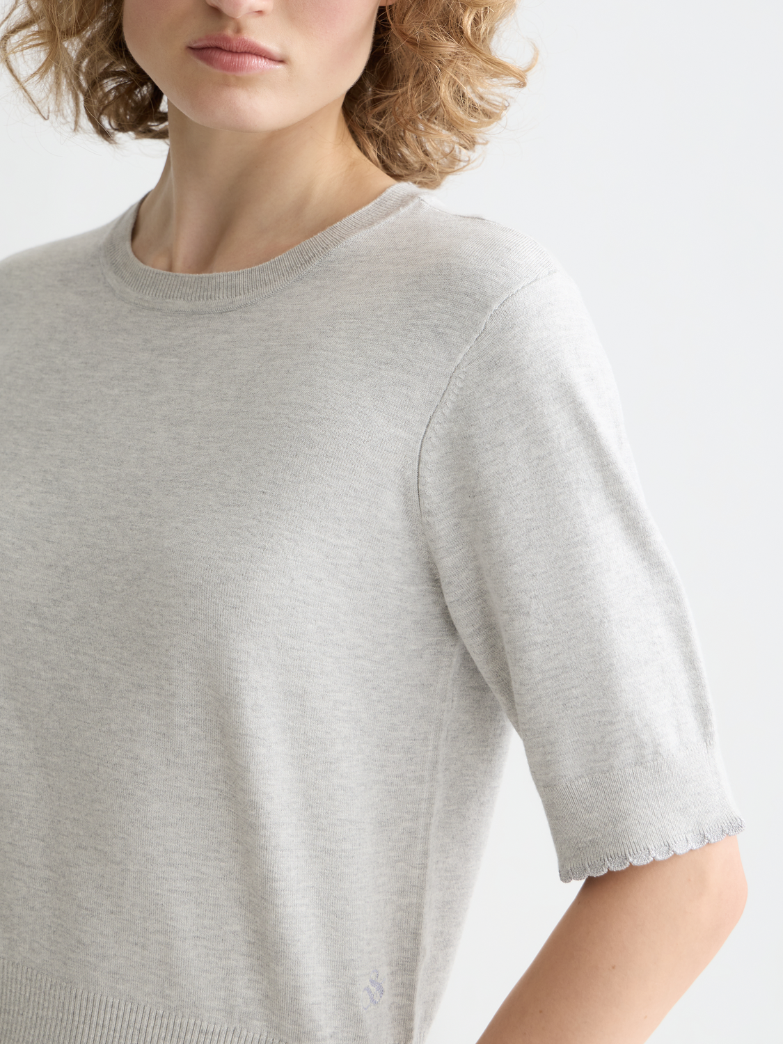Knitwear short-sleeved pullover top by Scotch & Soda, displayed on a hanger with a textured fabric and classic fit.