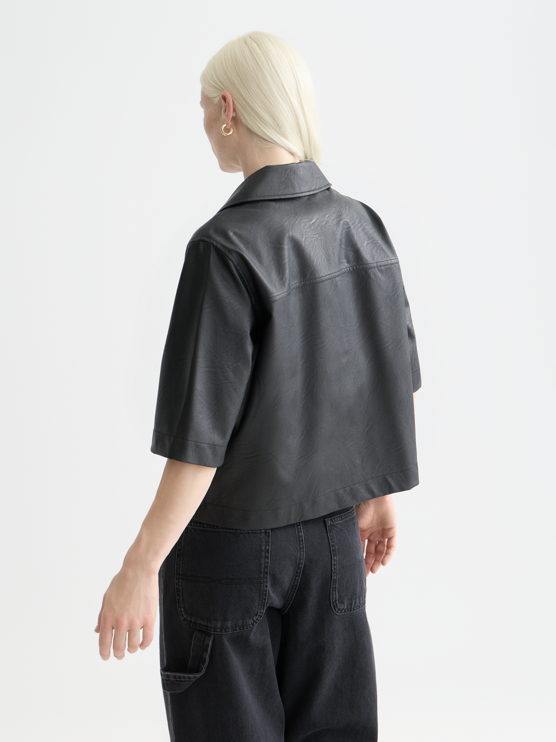 Black faux leather short-sleeve shirt by Scotch & Soda shown from the back, featuring sleek material and stylish design.