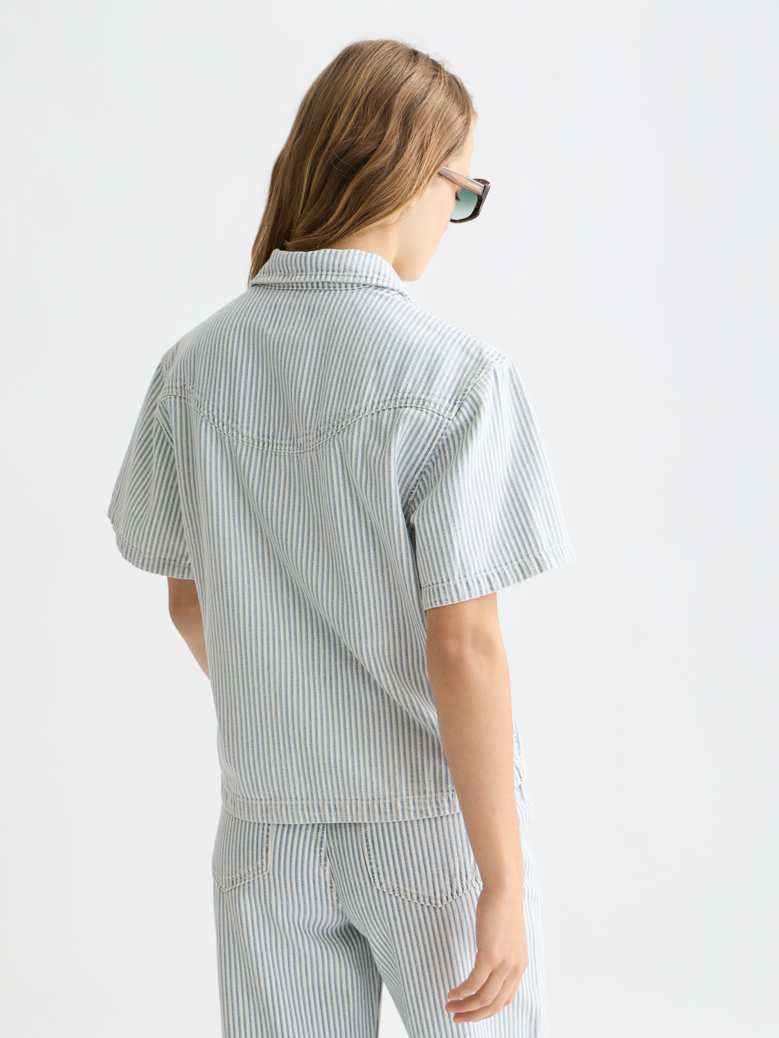 Short-sleeved denim shirt by Scotch & Soda, front view showing classic collar and button closure, casual summer style.