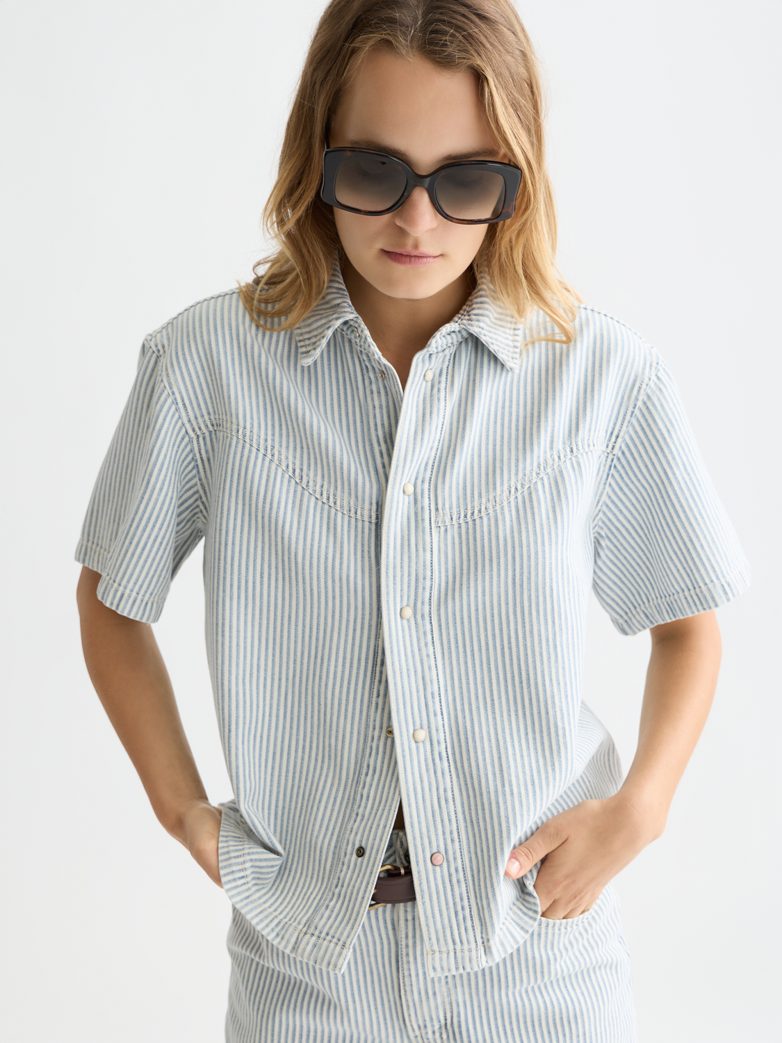 Short-sleeved denim shirt by Scotch & Soda, showing classic blue fabric with front button closure and casual fit.