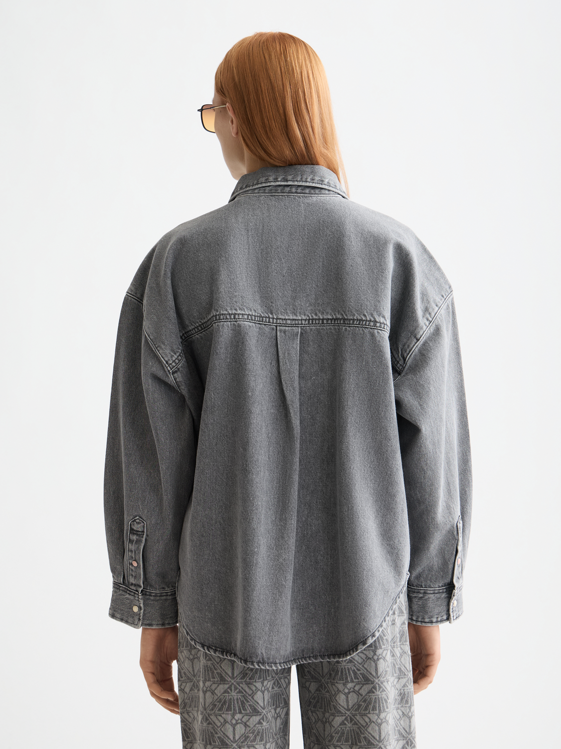 Washed denim Scotch & Soda long sleeve overshirt displayed on a model, showcasing casual, faded blue denim fabric and button-front design.