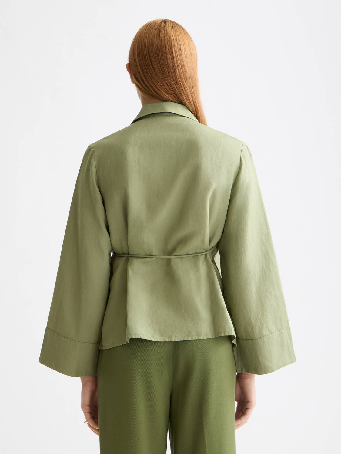 Long sleeve wrap shirt by Scotch & Soda, featuring a stylish design with a collar and button closure, shown on a model.