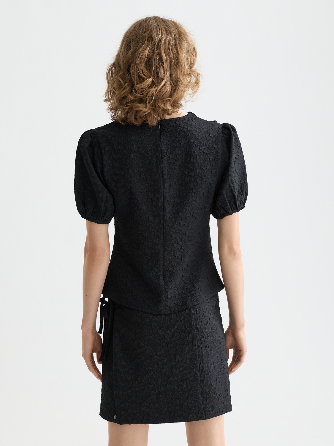 Black woven puff sleeve textured top by Scotch & Soda featuring a stylish design and detailed fabric texture.