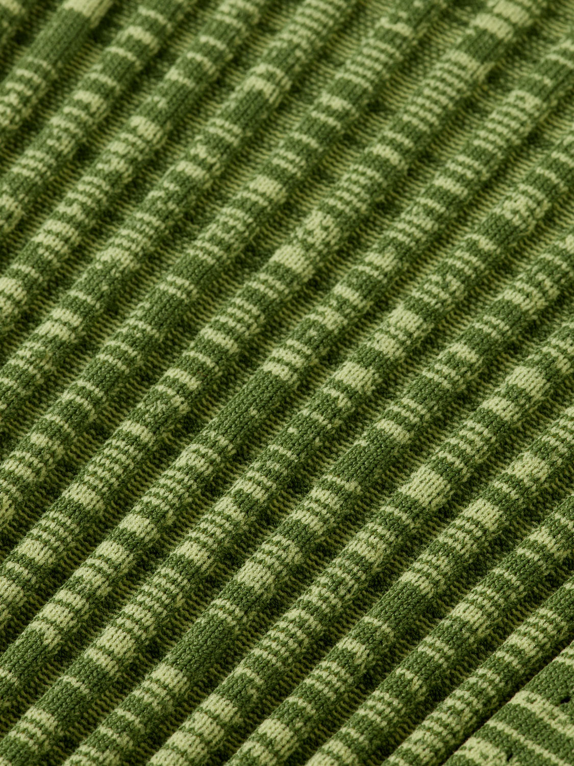 Ribbed knitted SCOTCH & SODA pullover in neutral color, close-up of textured knit fabric and ribbed collar details.