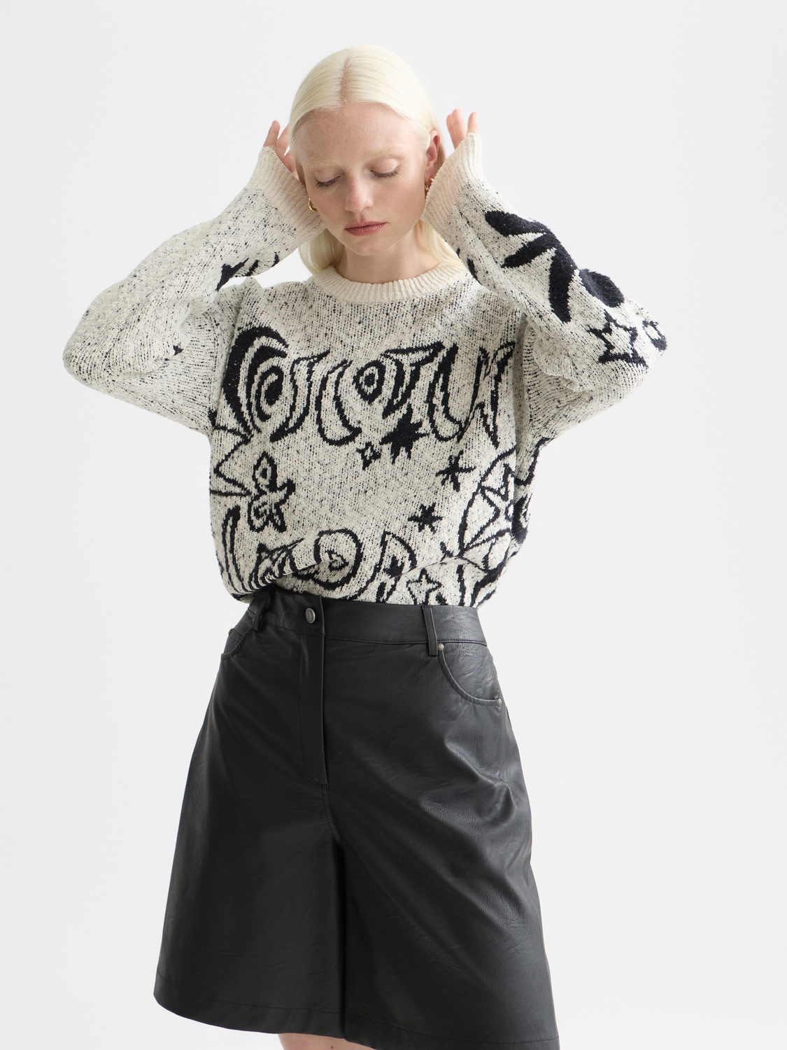 Scotch & Soda jacquard knit pullover featuring intricate patterns and a classic crewneck design, worn by a model.