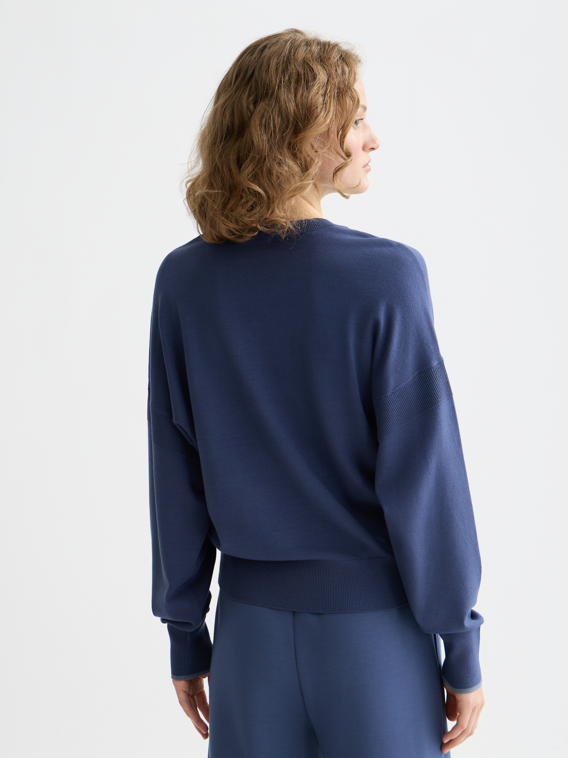 Relaxed-fit V-neck knit pullover by Scotch & Soda, shown from the back in soft, cozy fabric with ribbed cuffs and hem.
