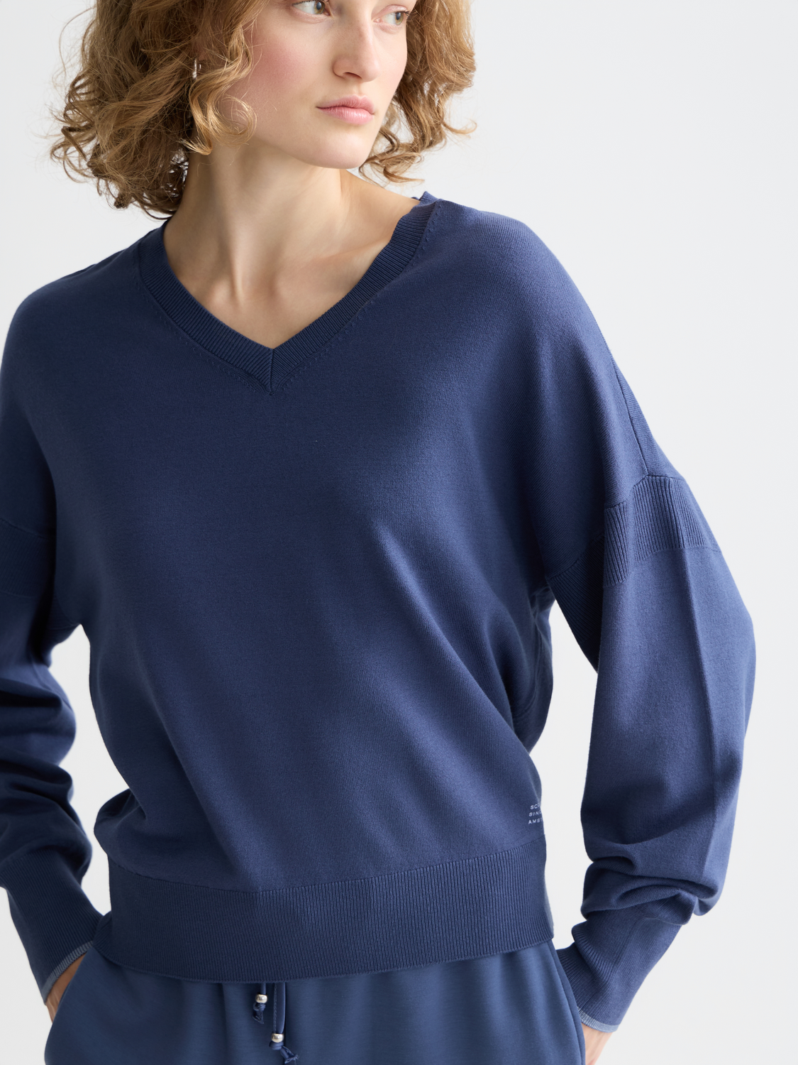 Light beige V-neck relaxed-fit knitwear pullover by Scotch & Soda, featuring a cozy, casual style with a soft knit texture.