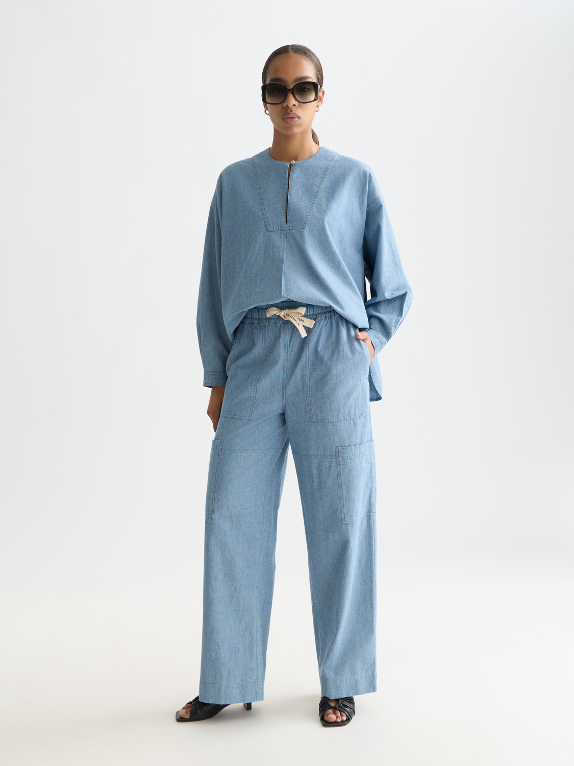 Denim bib shirt from Scotch & Soda, woven top with front bib detail, showcased on a hanger.