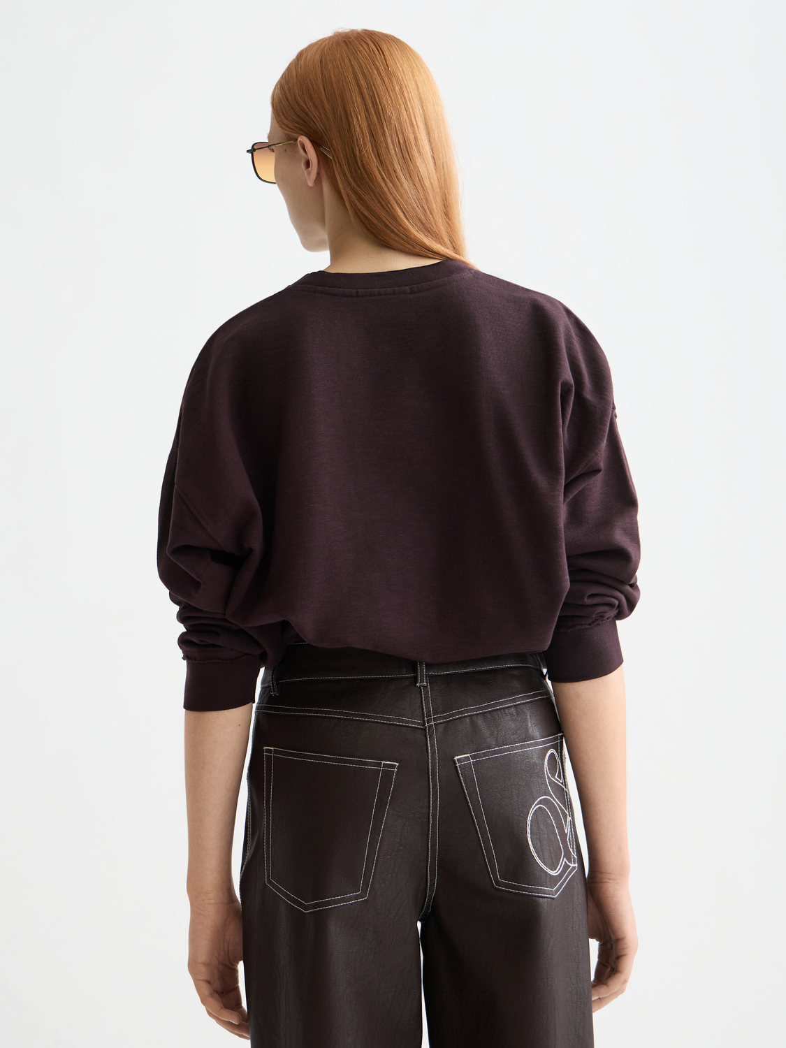 Black oversized sweatshirt by Scotch & Soda with a large logo print on the front, shown from the back view.