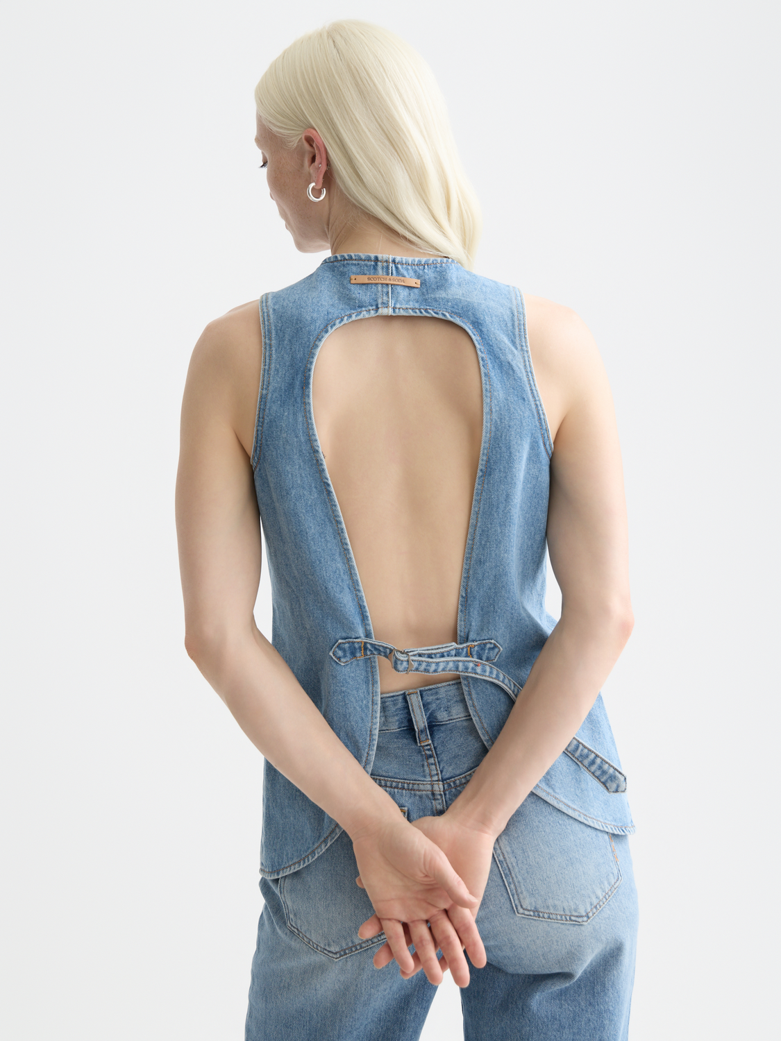 Western denim gilet by Scotch & Soda featuring a sleeveless design, front pockets, and classic denim wash.