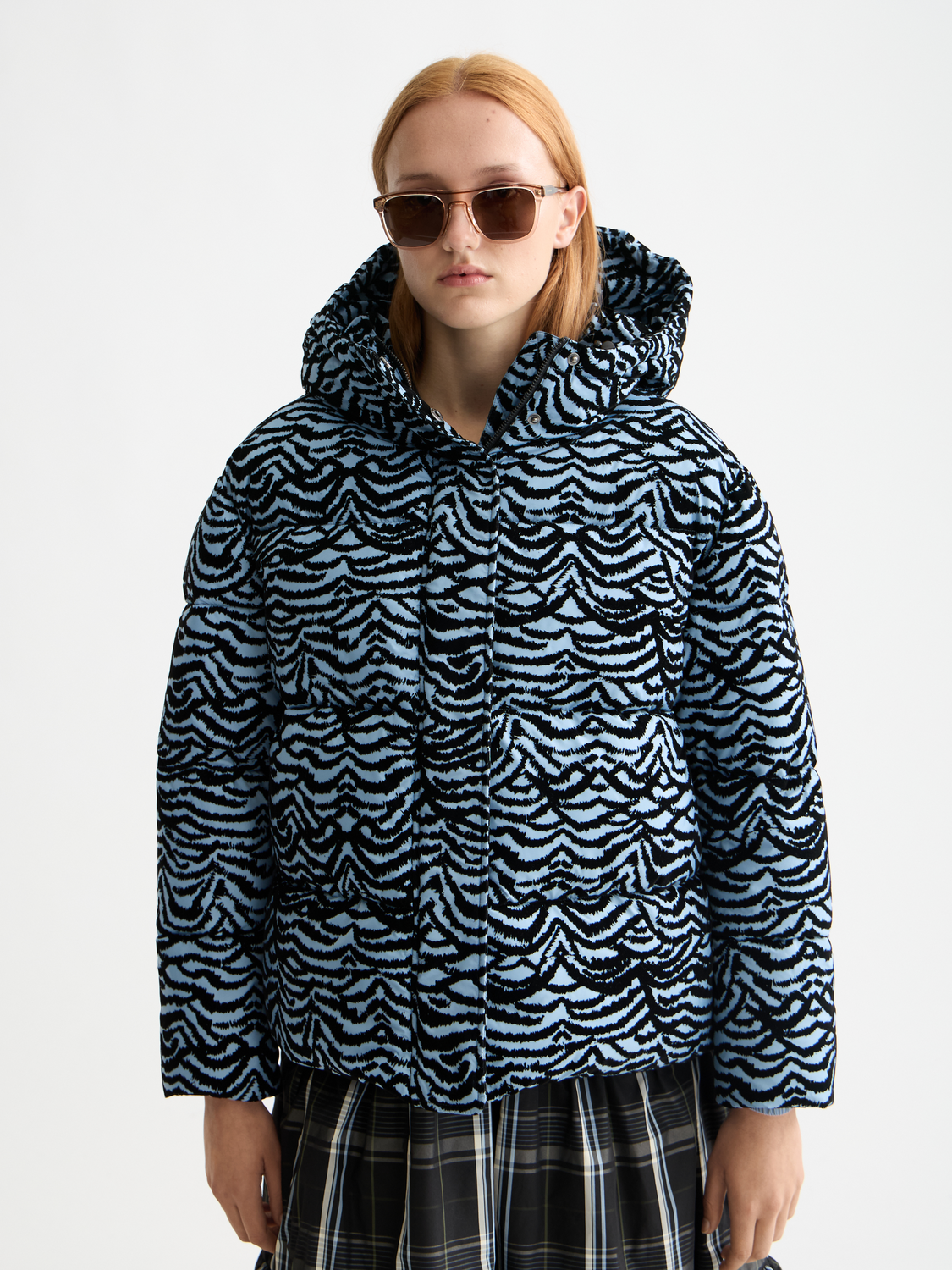 Scotch & Soda hooded puffer jacket with quilted design and zip closure, shown in a stylish outdoor setting.