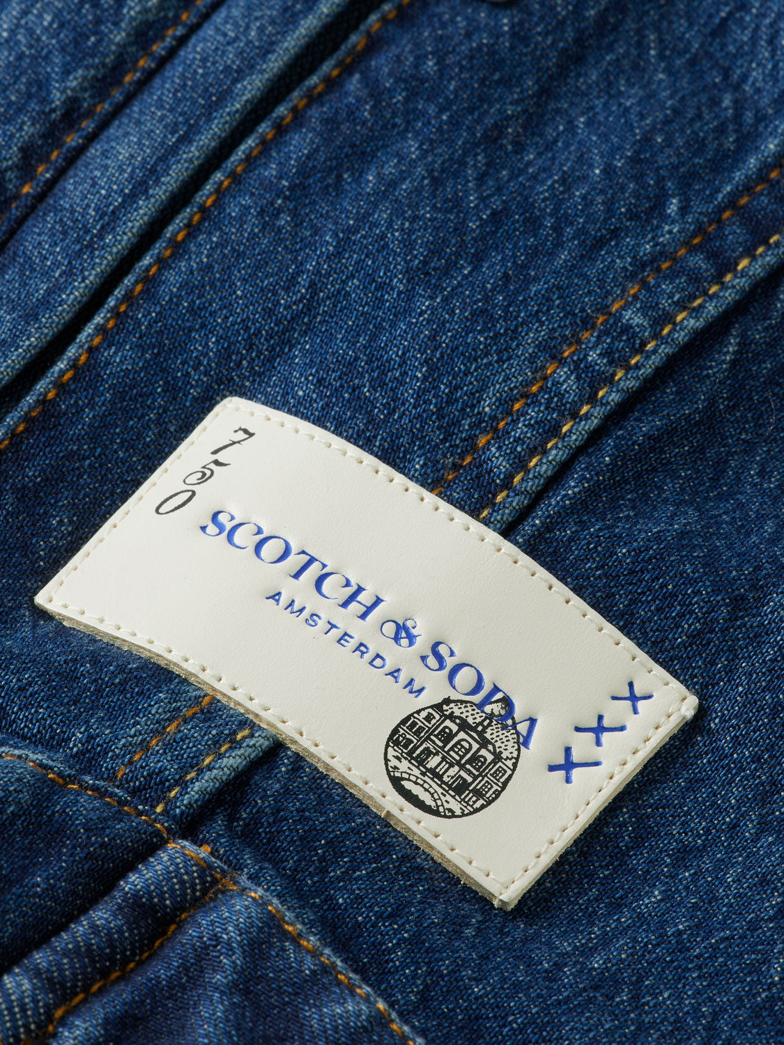 Cropped denim jacket by Scotch & Soda with classic blue wash and button-front design, styled on a hanger.