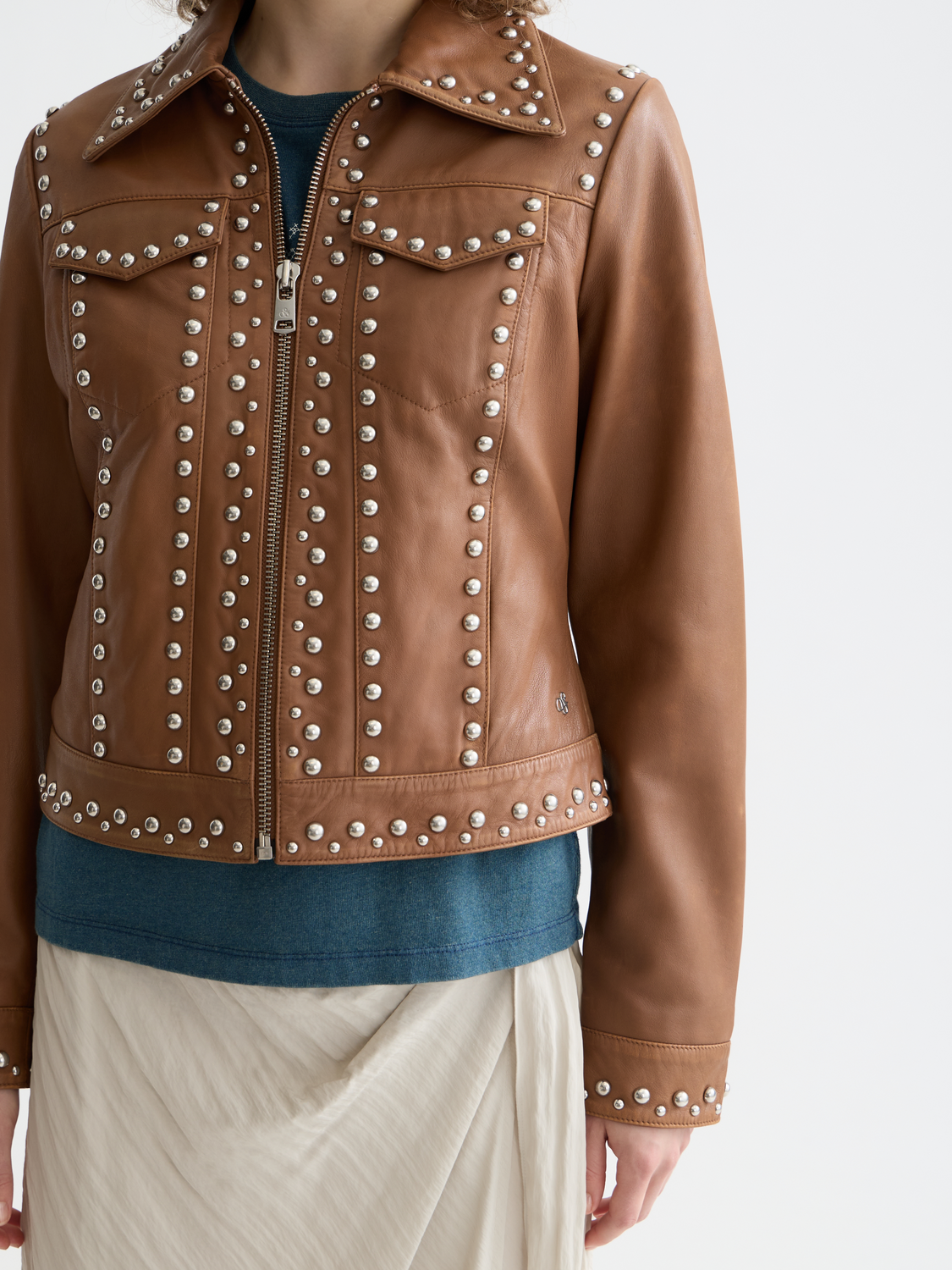 Leather trucker jacket by Scotch & Soda, showing the classic brown design with detailed stitching and button closure.