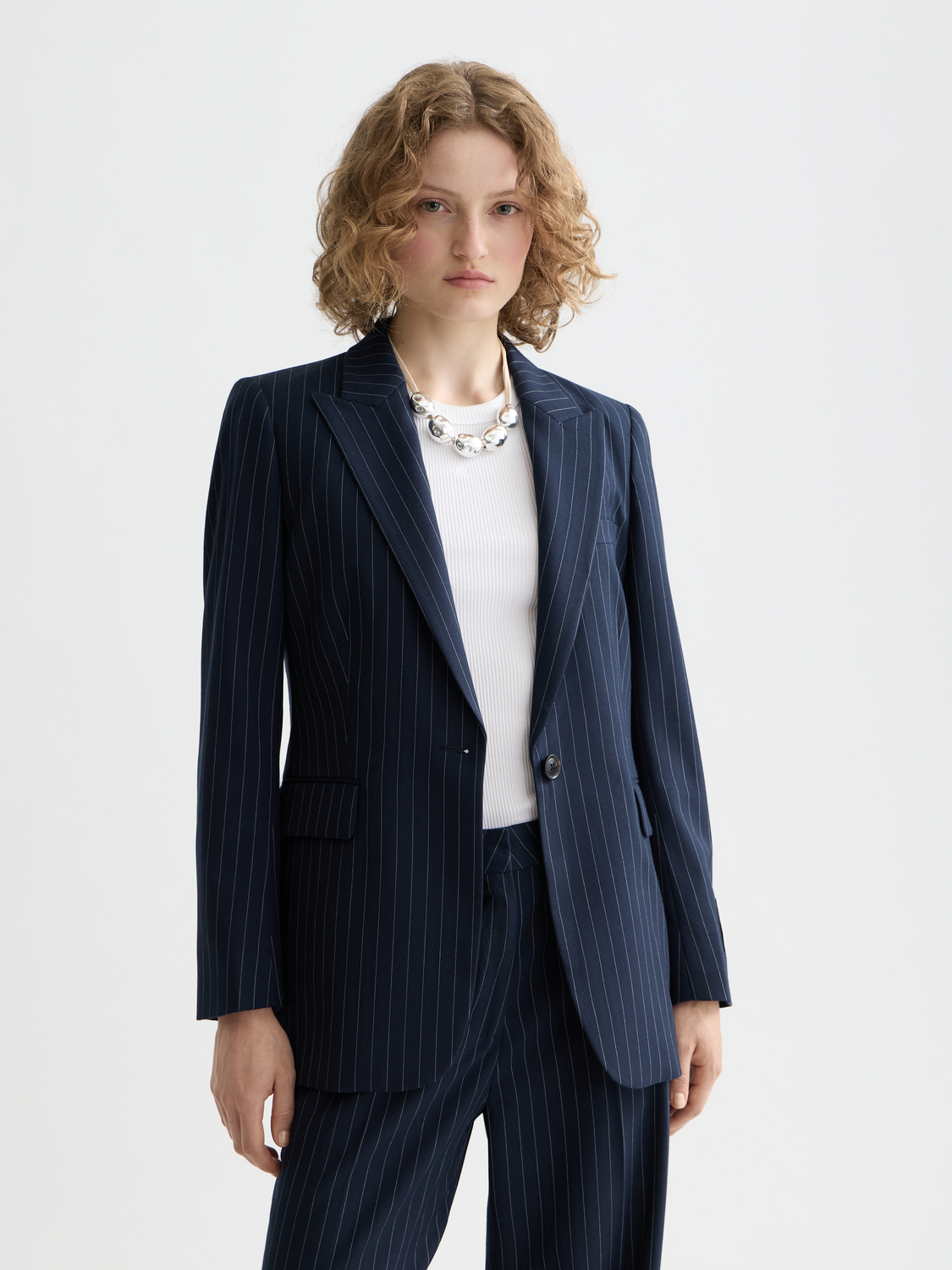 Fitted single-breasted blazer by Scotch & Soda in dark fabric, shown on a model with lapel collar and tailored fit.